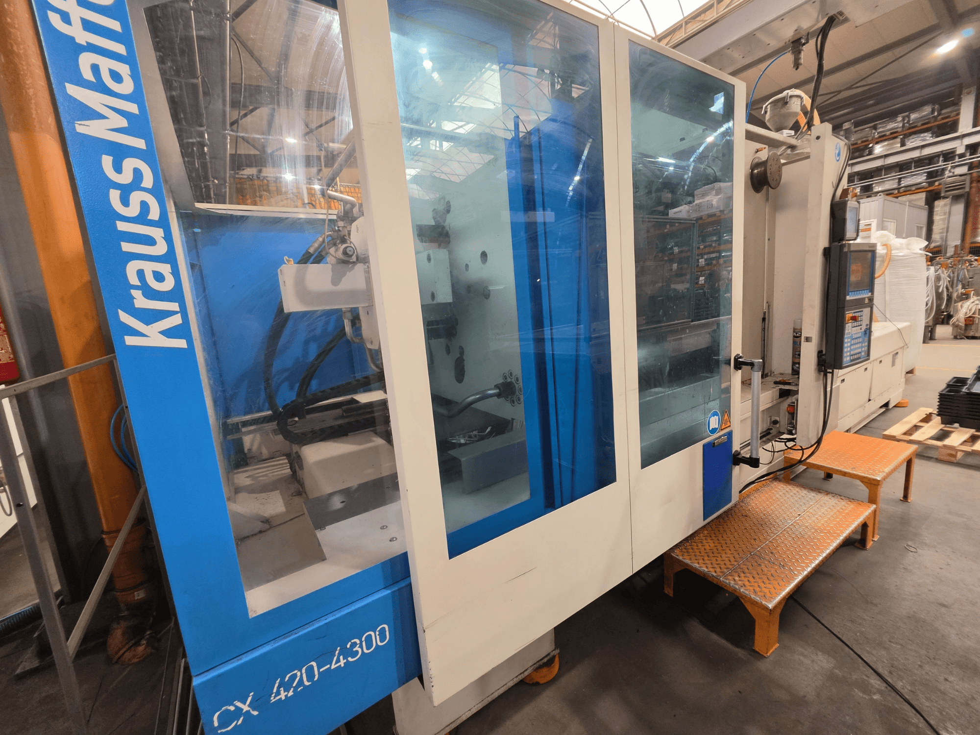 Krauss Maffei CX 420-4300 hidraulikus fröccsöntőgép, oldalnézet, a vezérlőpanel és az átlátszó panelek.