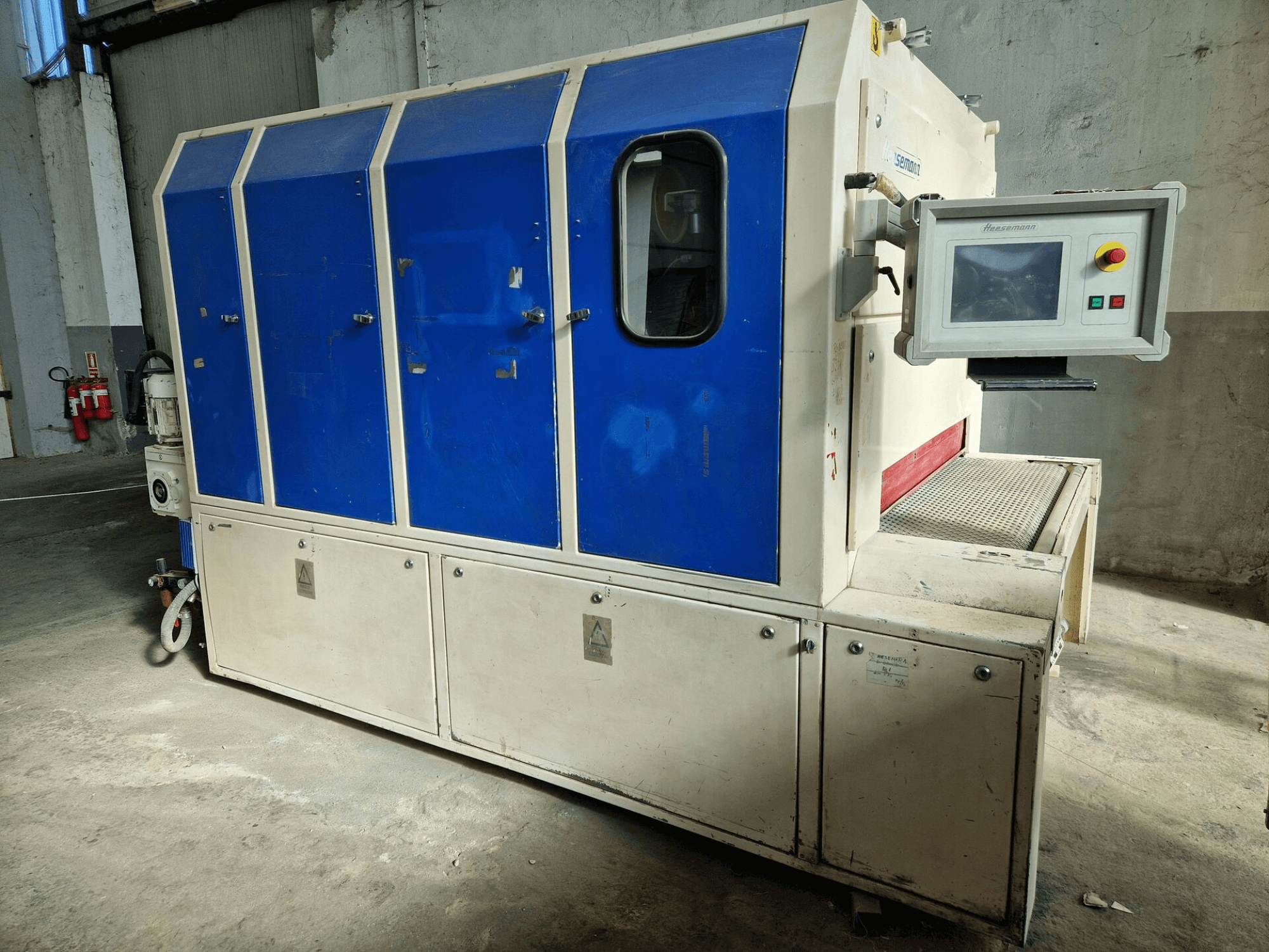 Ipari gép a "Sedecom" márkától, oldalnézet; kék panelek, vezérlőképernyő és texturált felület a termékek kezeléséhez.