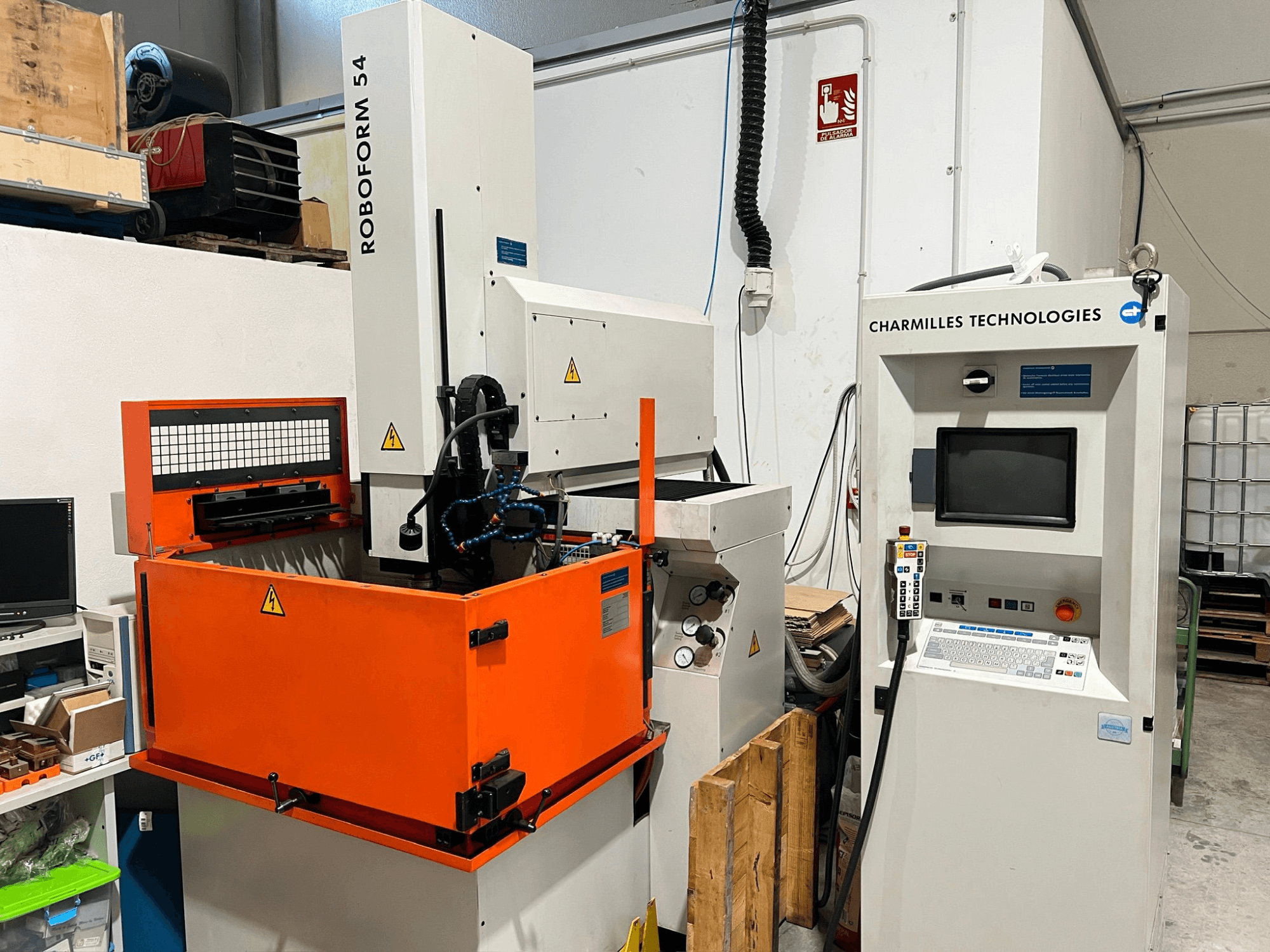 AgieCharmilles Roboform 54 süllyesztéses süllyesztéses EDM gép, elölnézetben, narancssárga munkatartállyal és vezérlőegységgel.