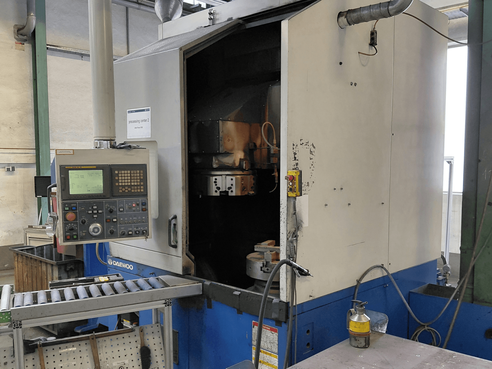 Daewoo Puma V550 függőleges esztergagép, elölnézetben a vezérlőpanel, az orsó és a hűtőfolyadék-csatlakozás.