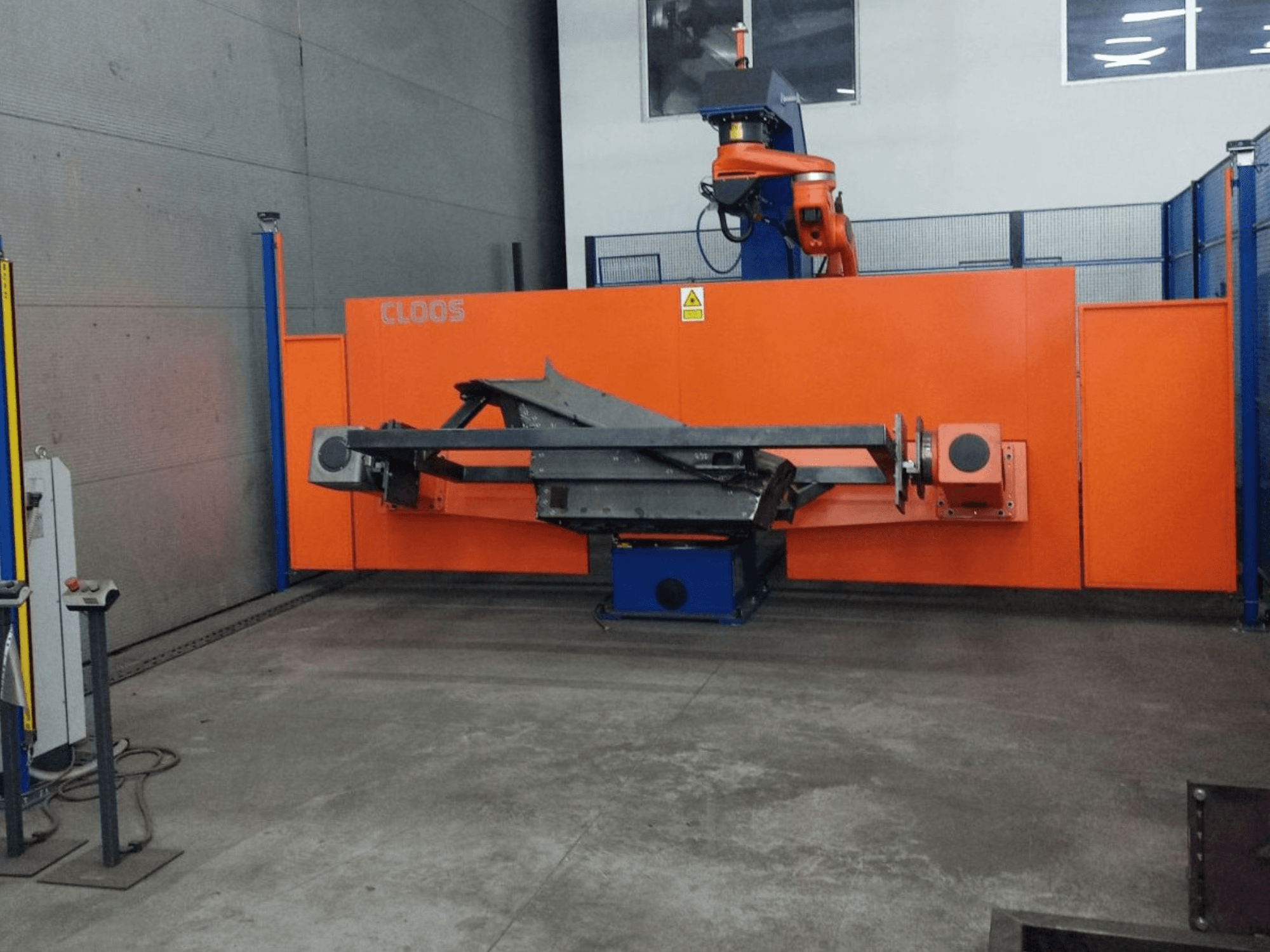 A CLOOS QIROX QRC-350-E automatizálási rendszer előlnézetből, robotkarral és fémszerkezettel ipari környezetben.