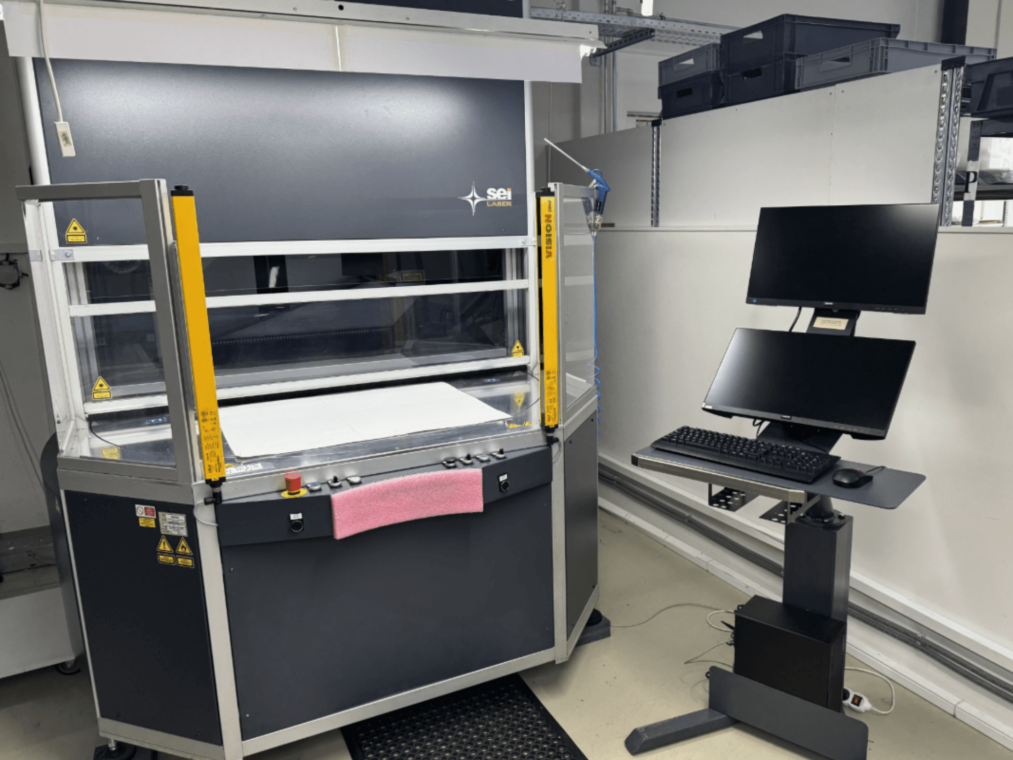 Az SEI Laser INFINITY 5070 V300 CO2 lézervágó gép elölnézetben, vezérlőpanellel és hozzáépített monitorállvánnyal.