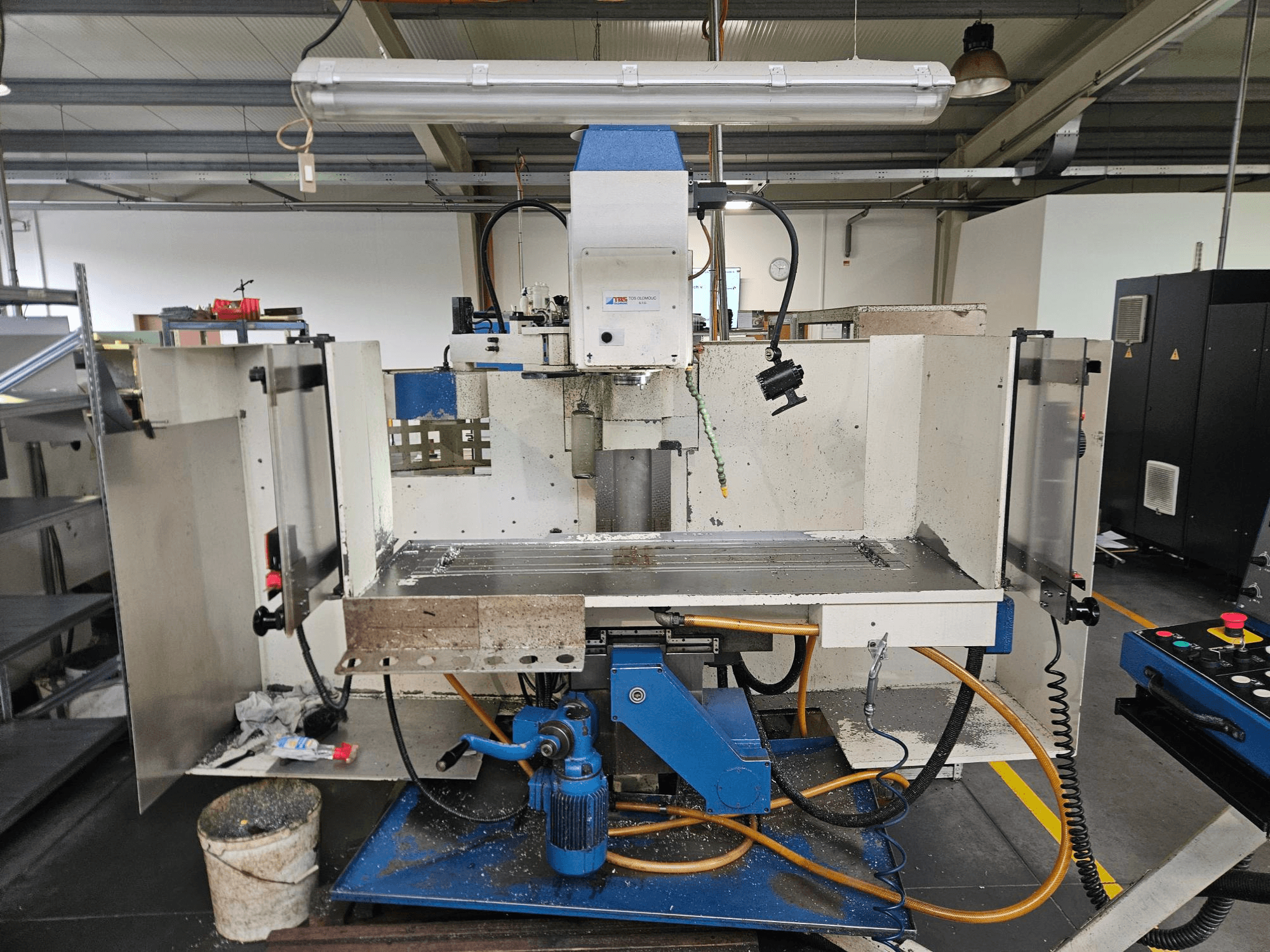 TOS Olomouc FV30 CNC Függőleges megmunkálóközpont egy műhelyben, elölnézetben a vezérlőpanel, a munkaasztal és a hűtőfolyadék-rendszer.