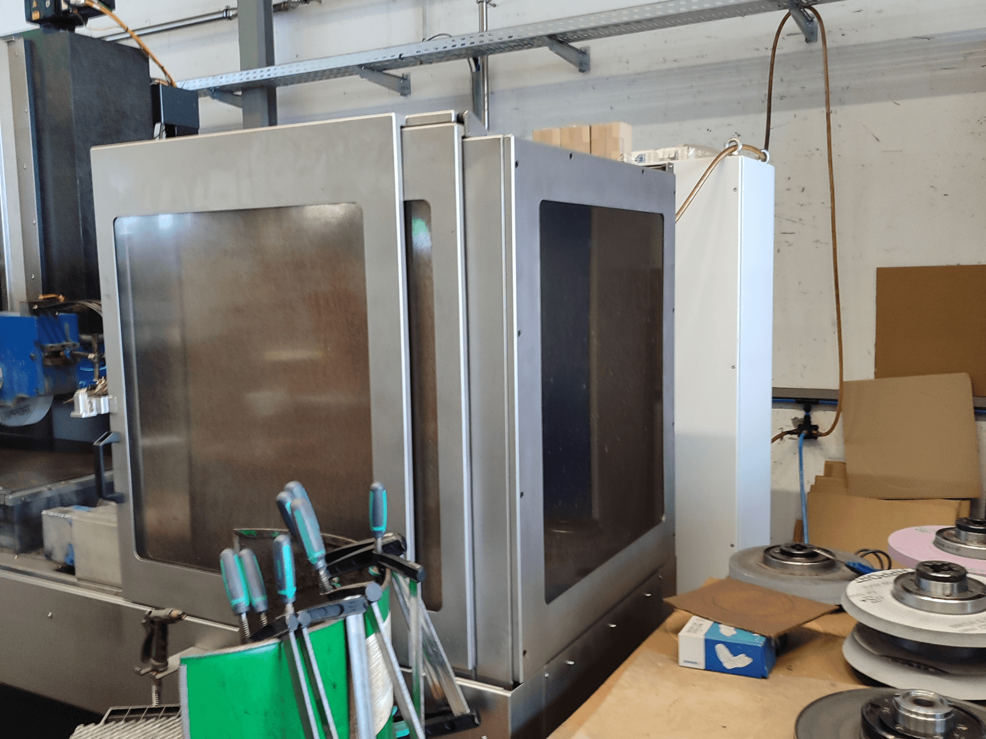 HEINZ STÖCKEL FD 1560 NC-T felületcsiszoló gép, oldalnézet a fémházzal és a csiszolóelemekkel műhelyben.