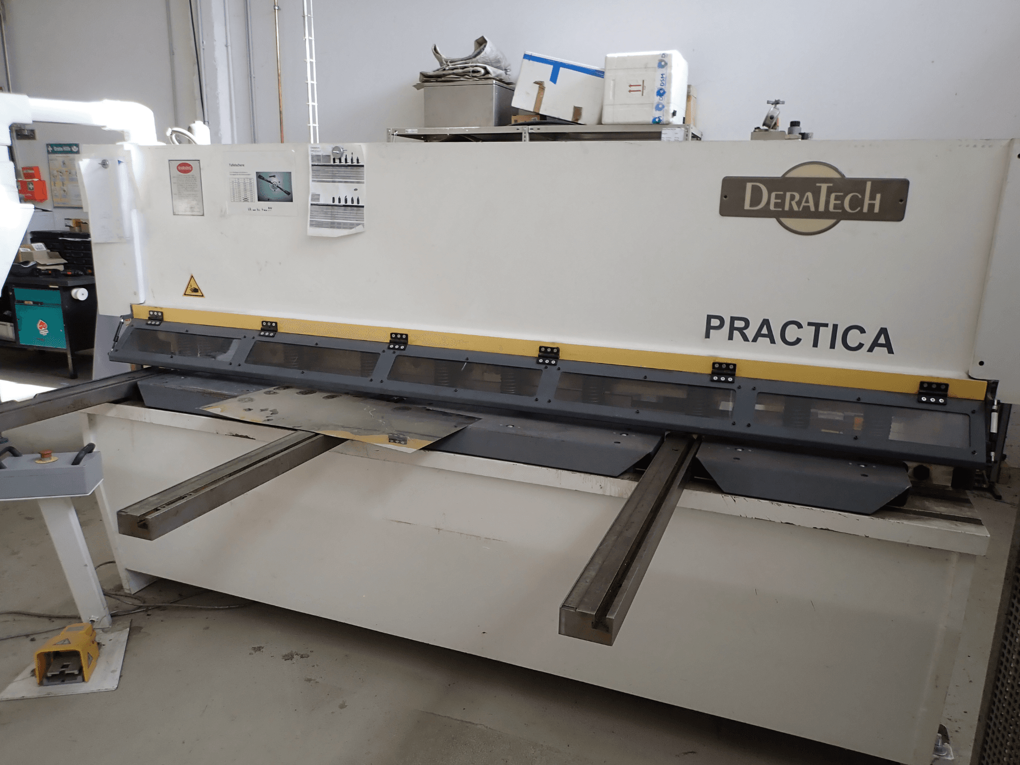 DERATECH Practica CNC nyírógép, elölnézet, a vágópengét és a fémlemezeket mutatja a munkafelületen.