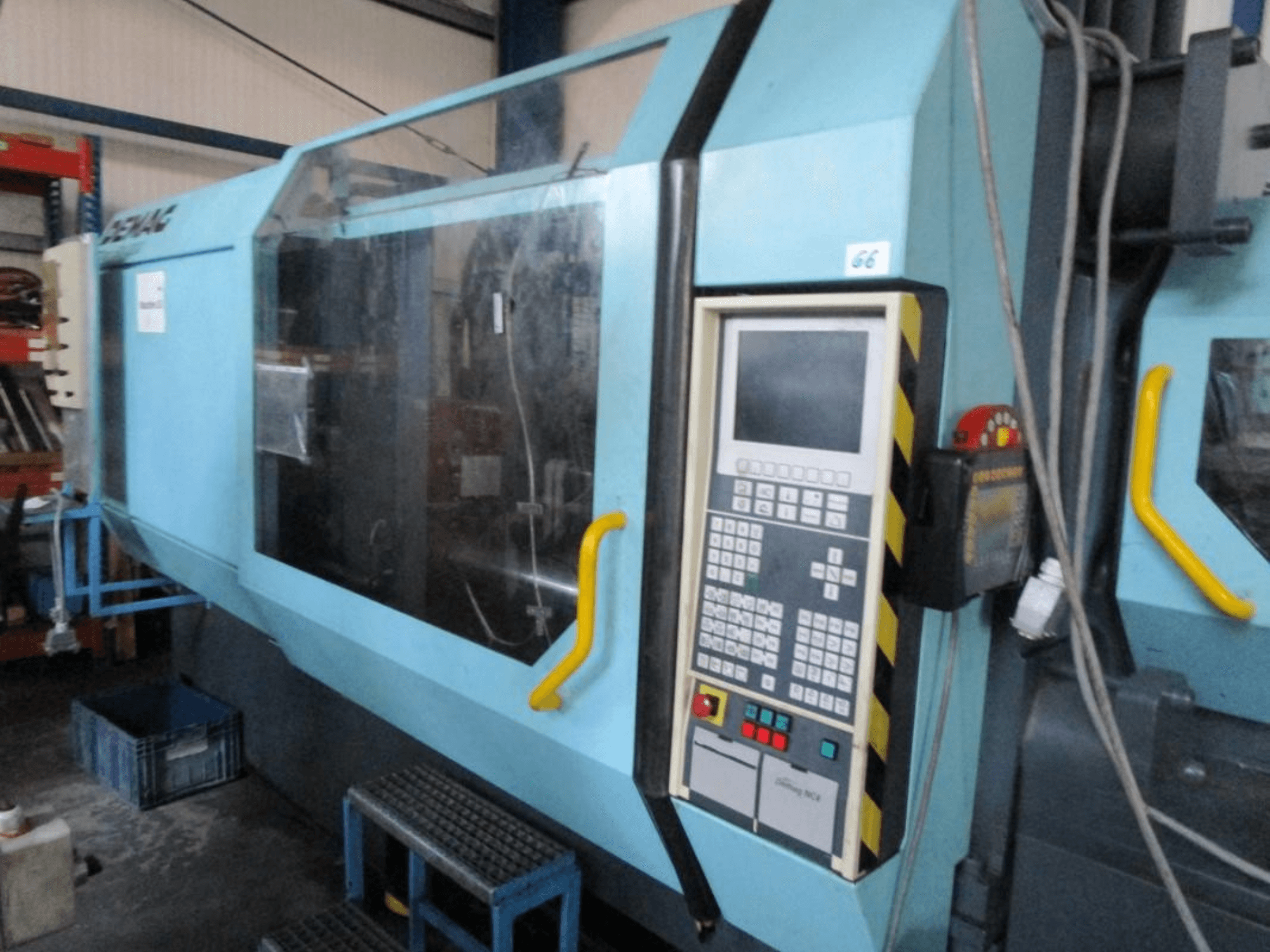 Demag Erdotech 500-3300 hidraulikus fröccsöntőgép, elölnézet, vezérlőpanel és átlátszó biztonsági burkolat.