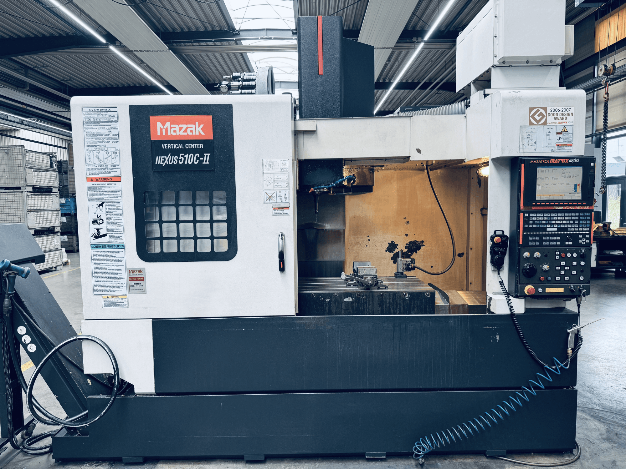 Mazak Nexus 510C-II függőleges megmunkálóközpont, elölnézet, amelyen látható a vezérlőpanel, a munkaterület és a működési jellemzők egy műhelyi környezetben.