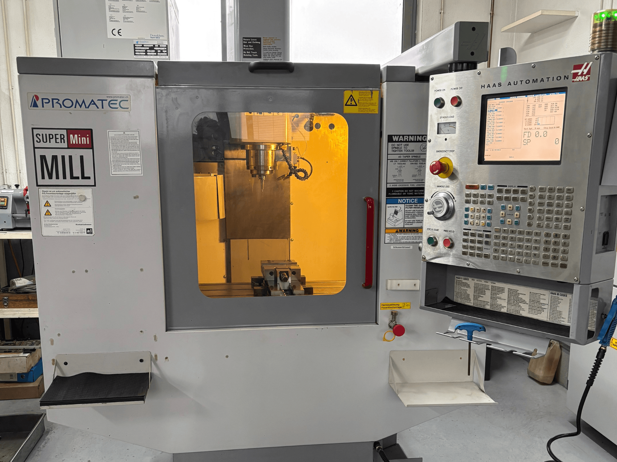 Promatec Super Mini Mill elölnézetben, Haas Automation vezérlőpanellel és látható vágószerszámmal felszerelve.