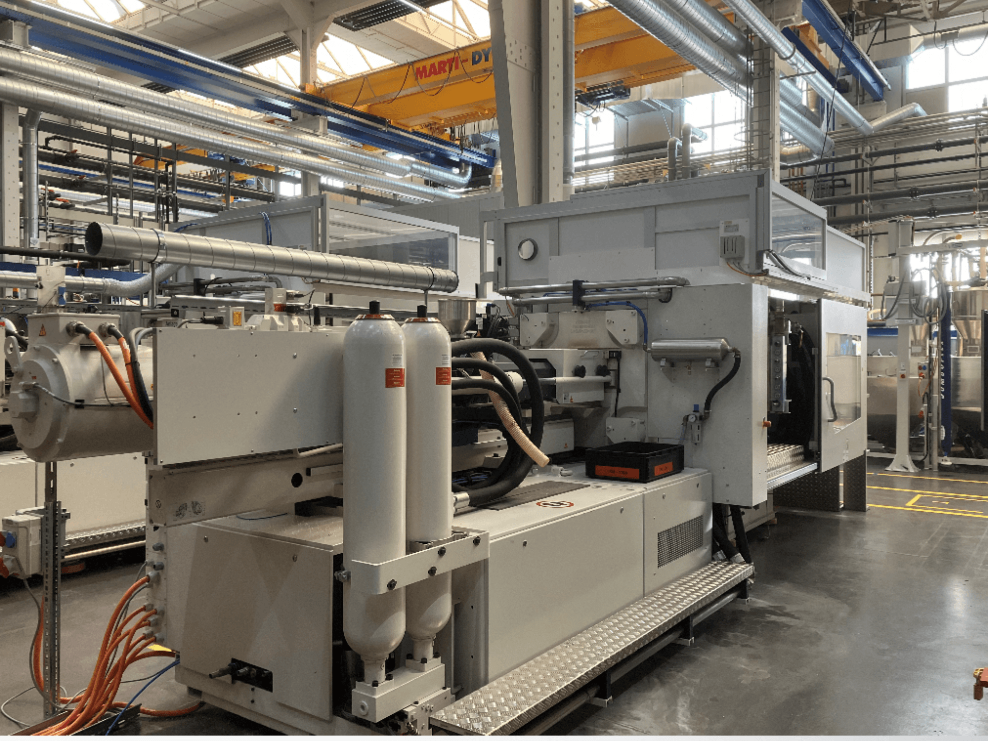 Ipari gép oldalnézetben, több tömlővel, két függőleges tartállyal és vezérlőpanellel; márka/modell nem látható.