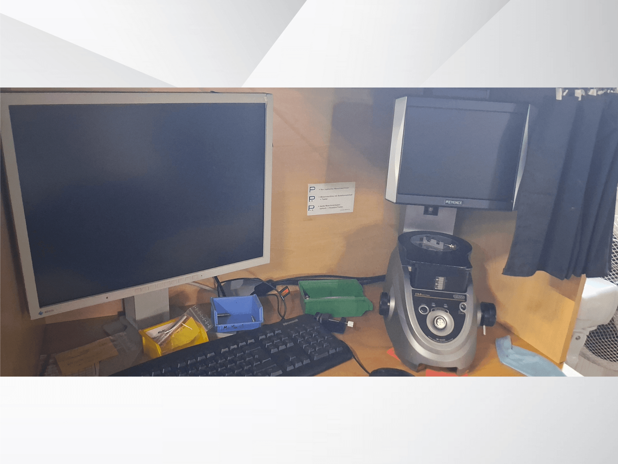 Számítógép-monitor billentyűzettel, PEVA márkájú kijelző és egy szürke laboratóriumi eszköz egy fa íróasztalon, válogatott tálcákkal és papírmunkával.