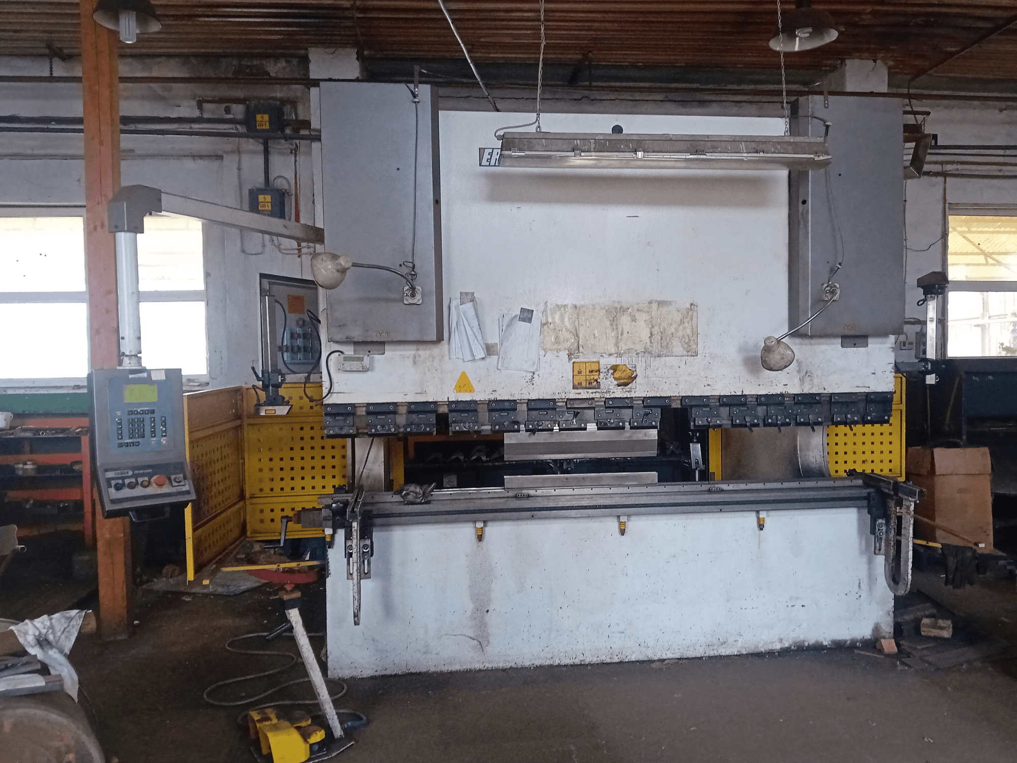 ERMAK CNC HAP 3100x300 hidraulikus prés elölnézetben, vezérlőpanel és munkapad műhelyben.