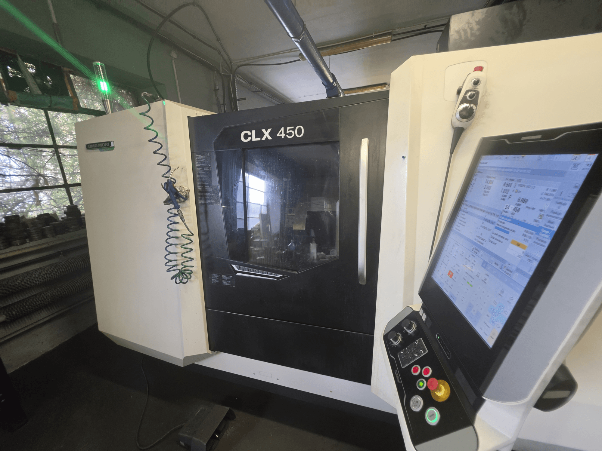 DMG MORI CLX 450 V3 vízszintes eszterga, elölnézet a vezérlőpanellel és a működési adatokat megjelenítő monitorral.