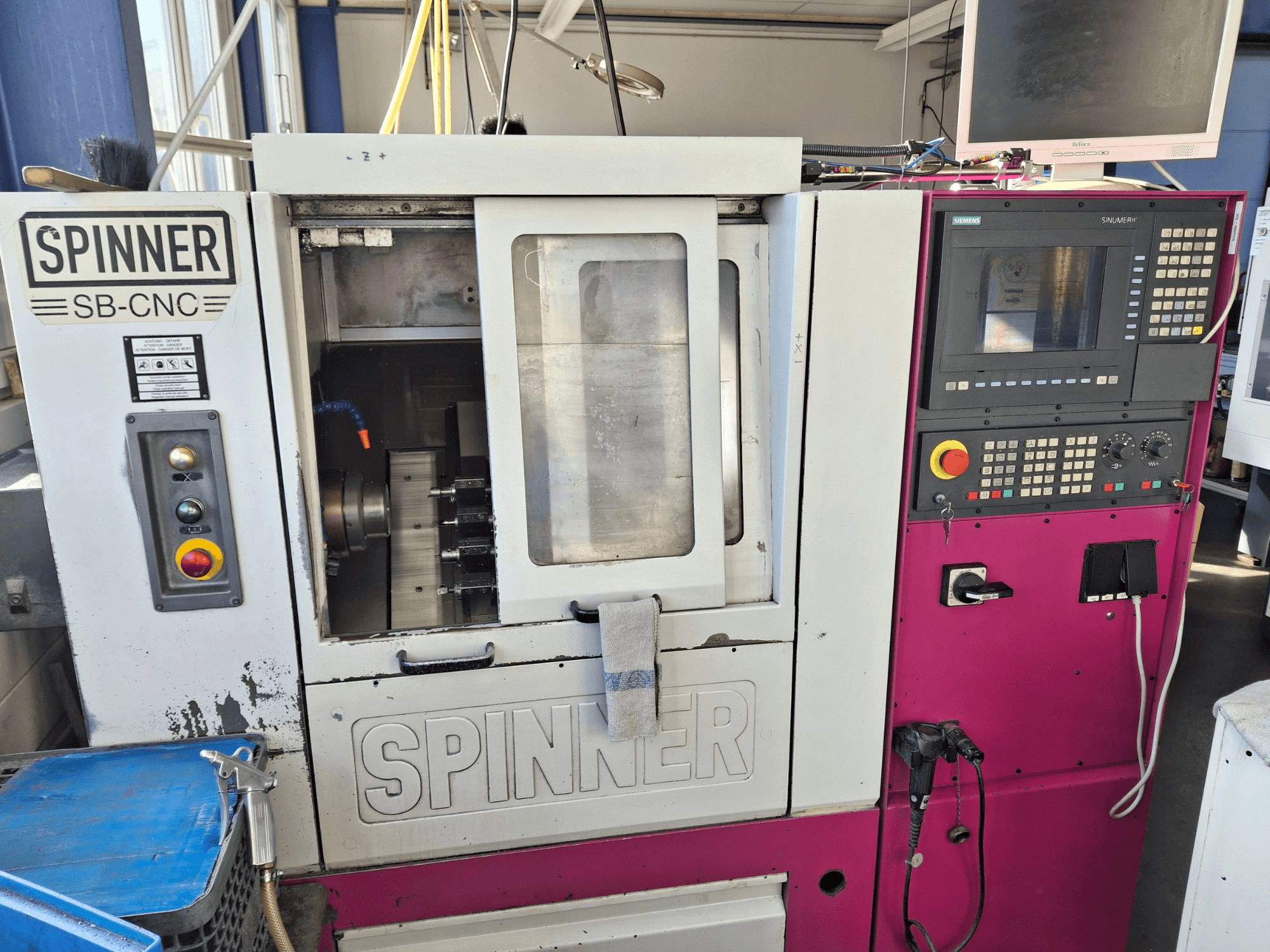 Vízszintes esztergagép SPINNER SB-CNC, elölnézetben a kezelőpanel, a szerszámtartó és a működési kijelzők.