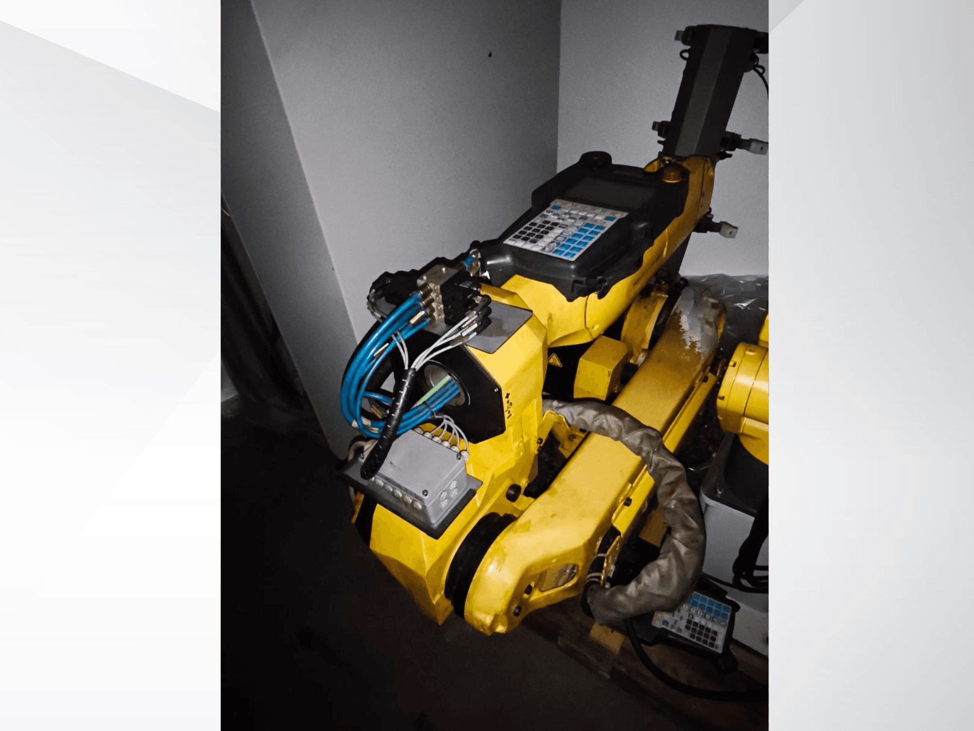 FANUC M-20iA robotkar oldalnézetben, a sárga test, a vezérlőpanel és a csatlakoztatott vezetékek.