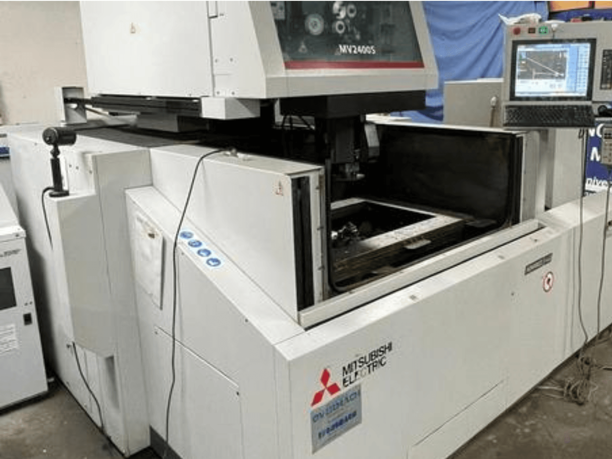 Mitsubishi Electric MV2400S drótvágó szikraforgácsoló gép, elölnézetből, a vezérlőpanel és a nyitott munkaterület látható.