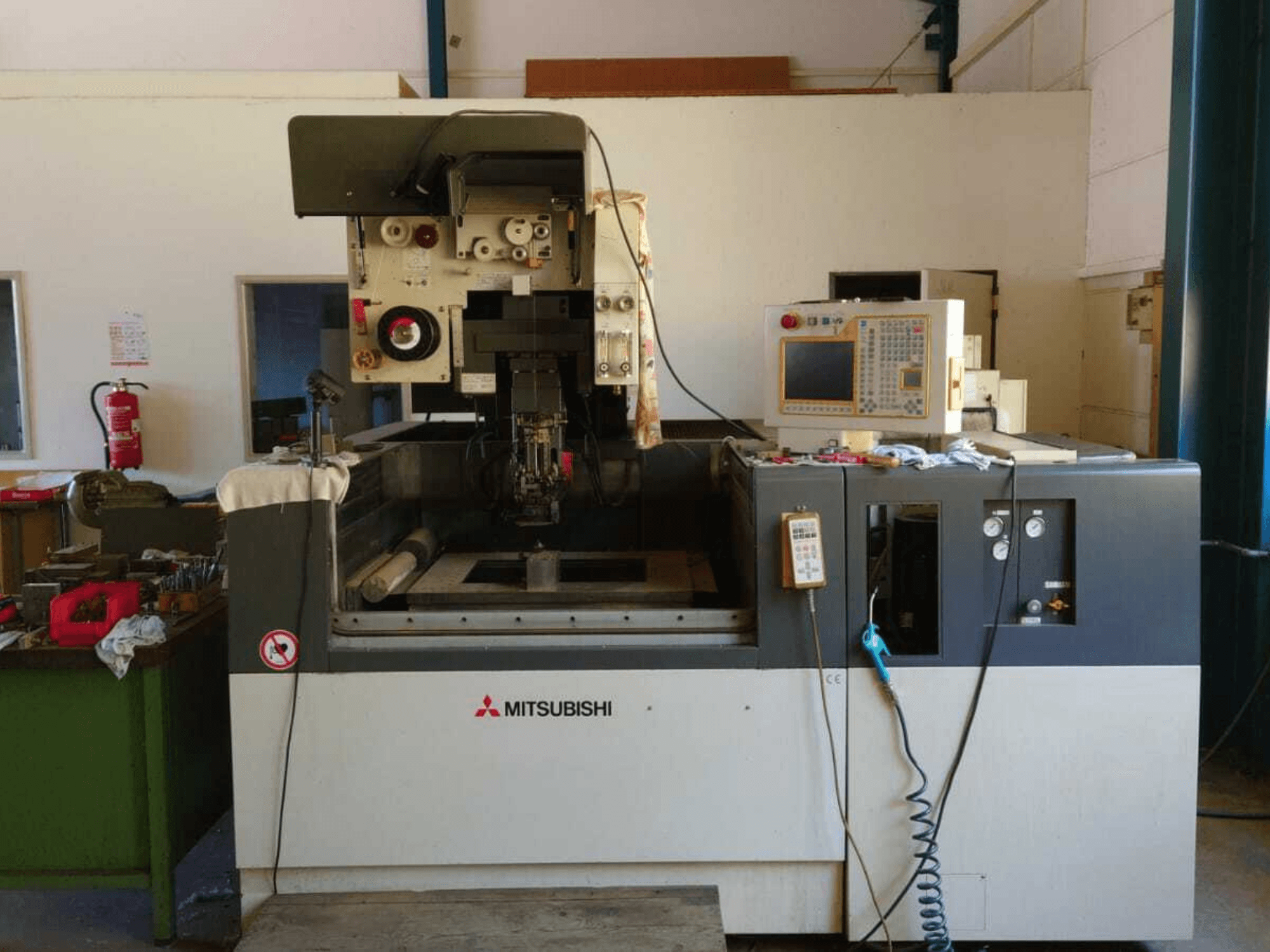 A Mitsubishi FA20 huzalvágó gép elölnézete, amelyen látható a vezérlőpanel, a munkaterület és a biztonsági jelzések.