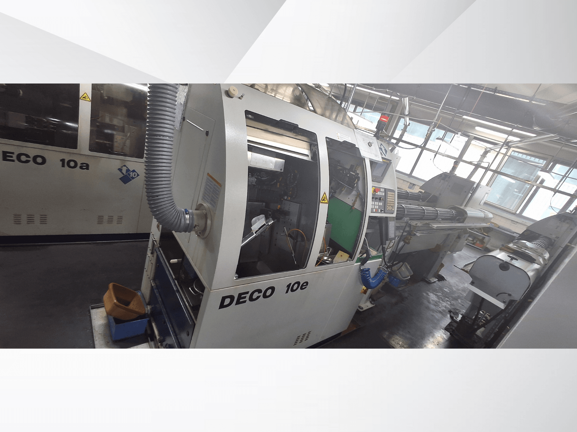 DECO 10e CNC-gép oldalnézetben, vezérlőpanel, zöld belső tér és csatlakoztatott kipufogócső.