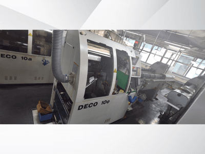 DECO 10e CNC-gép oldalnézetben, vezérlőpanel, zöld belső tér és csatlakoztatott kipufogócső.