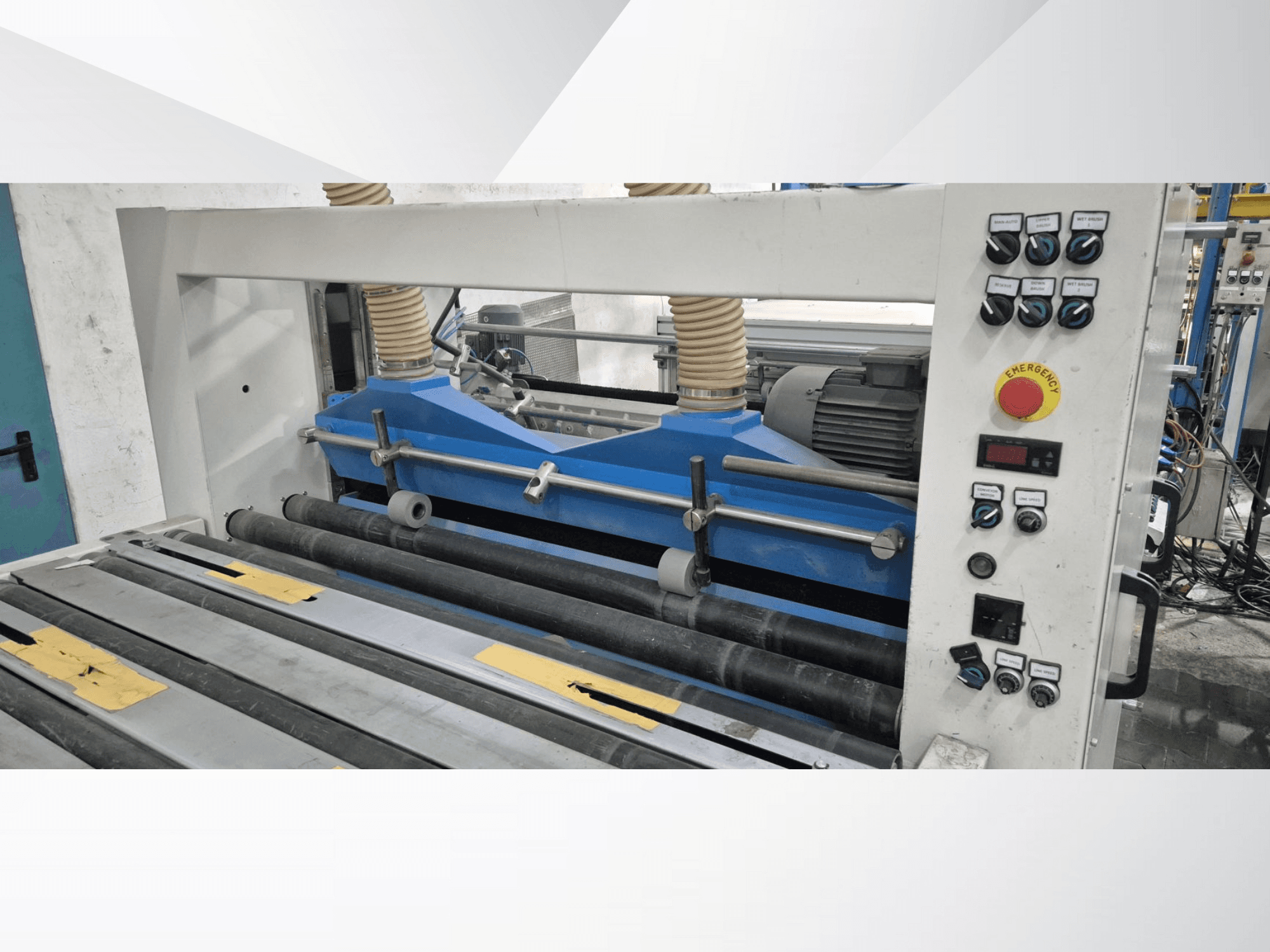 Ipari gördülőgép kék alkatrészekkel, elölnézetben, vezérlőpanellel és vészleállító gombbal.