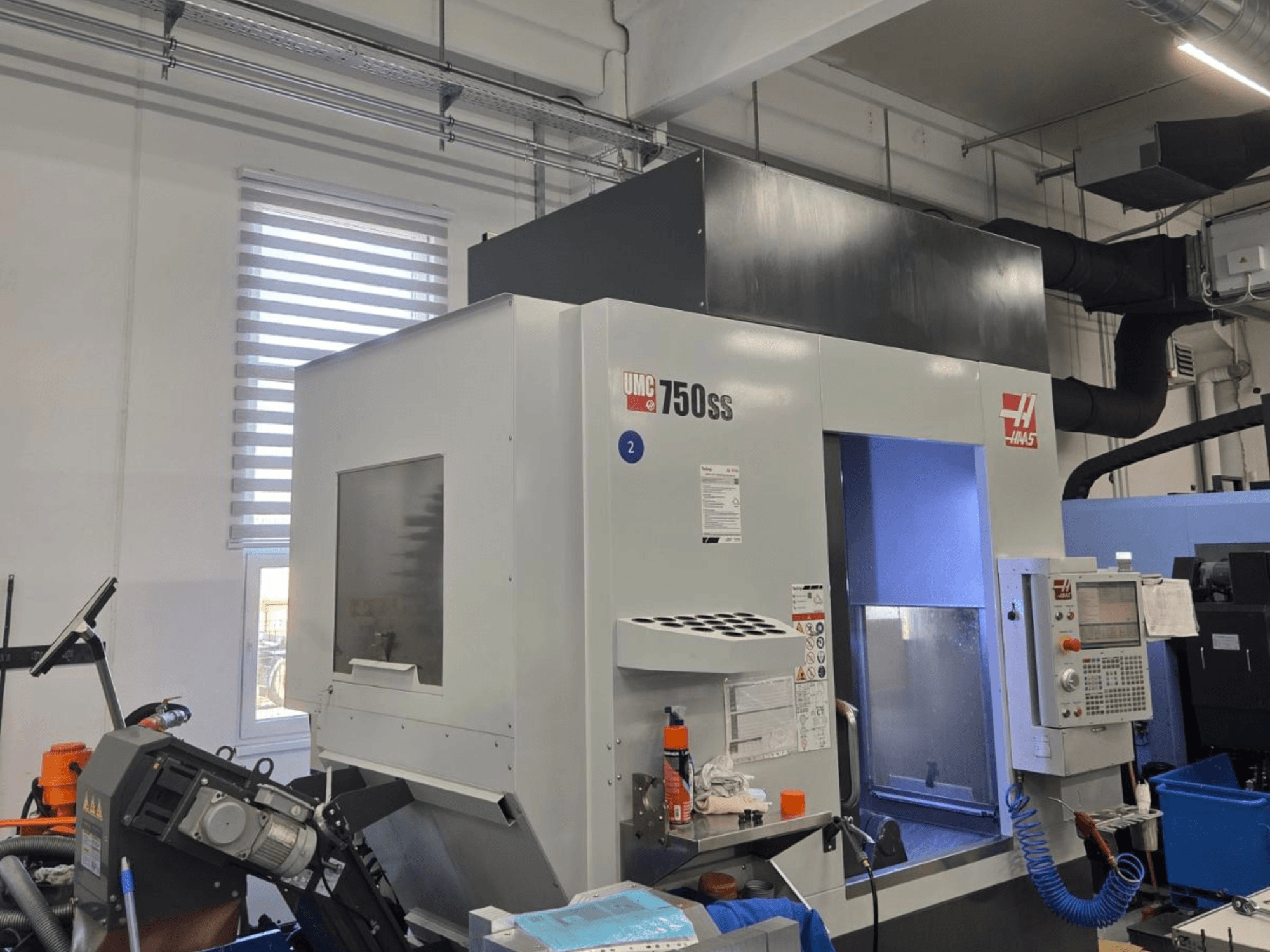 Haas UMC-750SS függőleges megmunkálóközpont, elölnézet, vezérlőpanel és szabad hozzáférés a megmunkálási területhez.