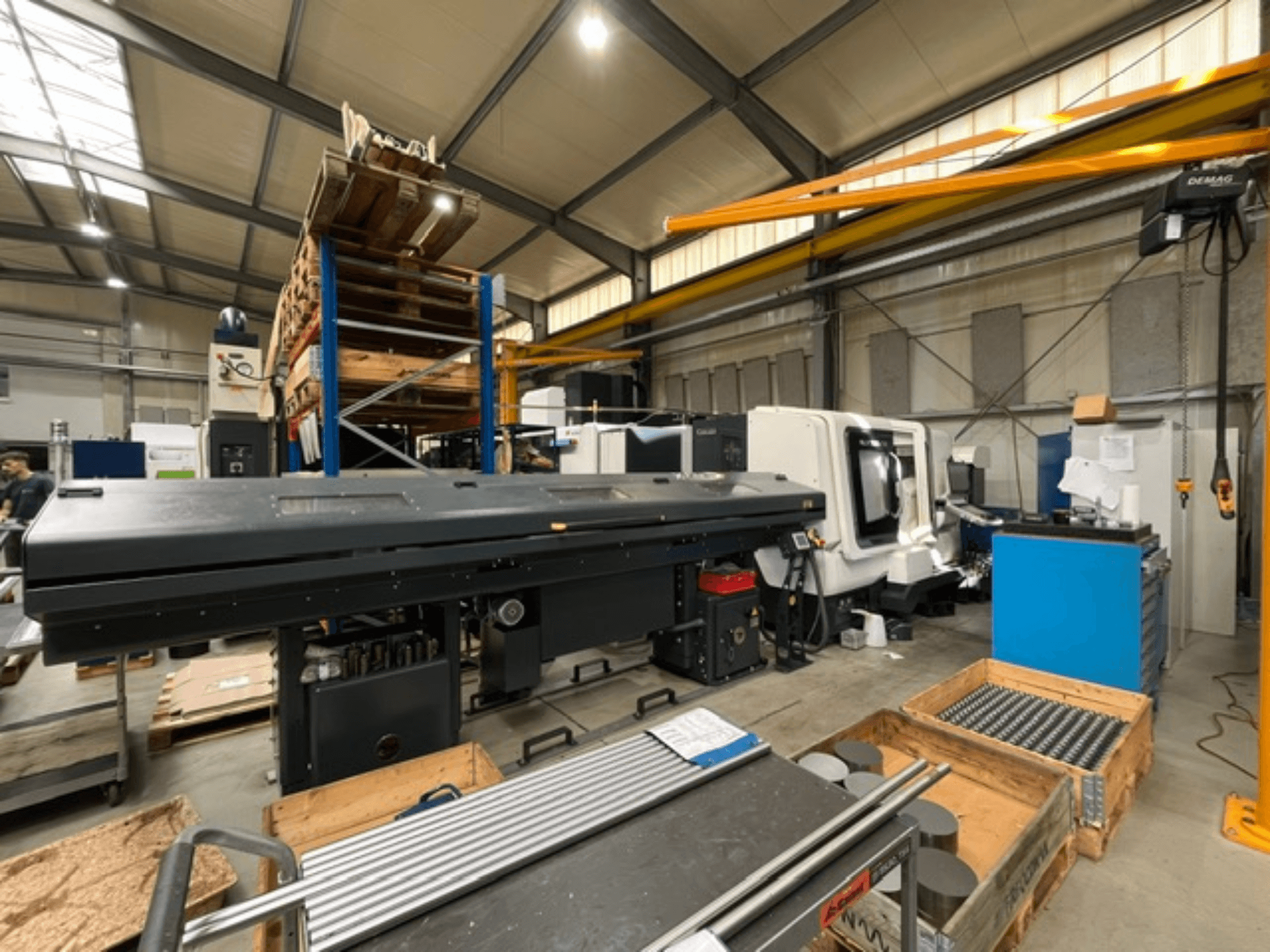 DMG MORI MORI NLX 2500/700 SY vízszintes eszterga gyári környezetben, oldalról nézve, a szerszámok és a paletták láthatók.