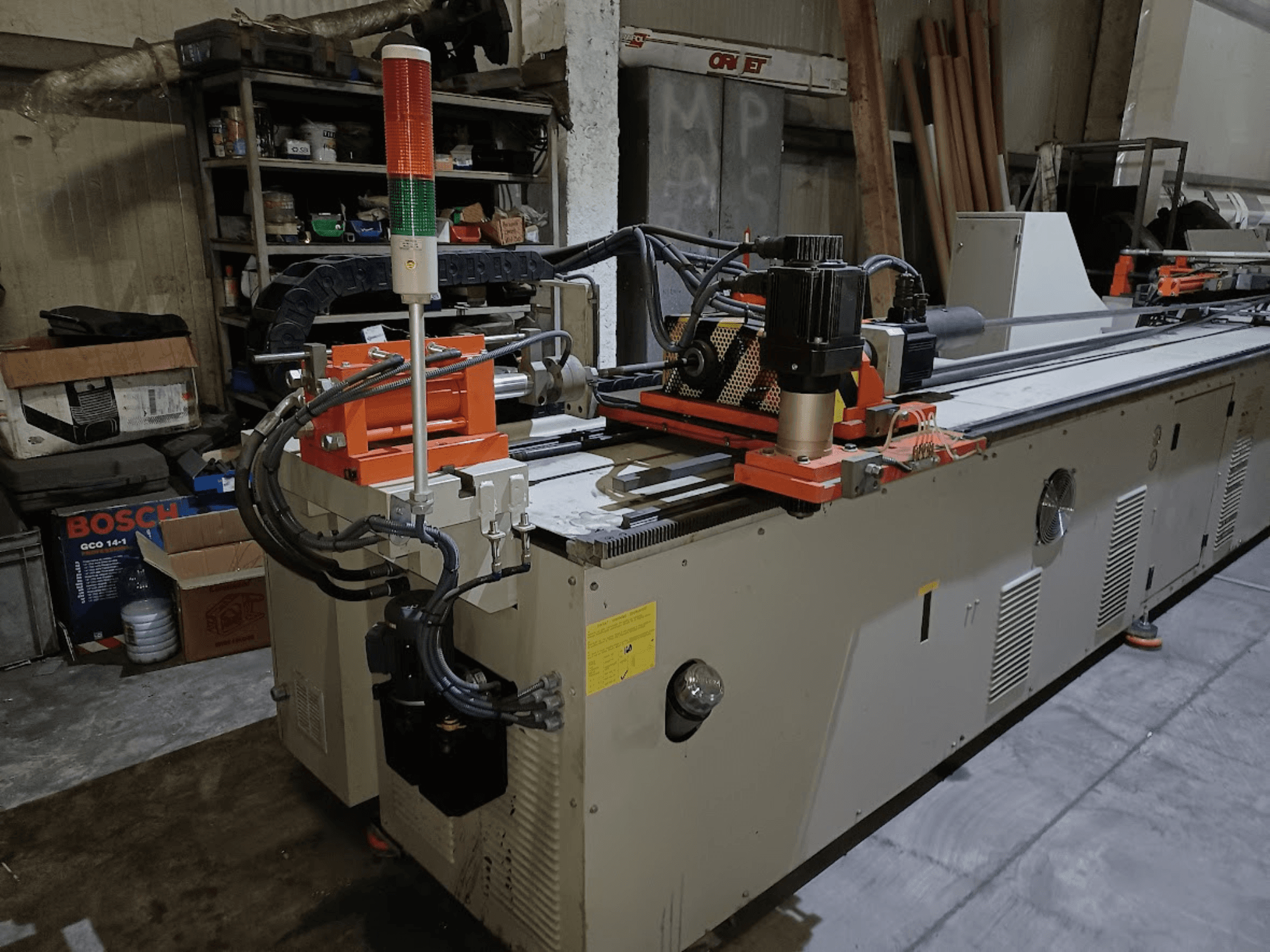 A CANSA CNC 51 R1 hajlítógép oldalnézete, amelyen látható a vezérlőpanel, a motor és a jelzőfények egy műhelyi környezetben.