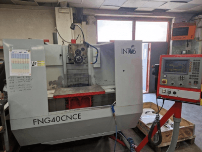 INTOS FNG40CNC gép, előlnézet, vezérlőpanel, kezelőelemek és fém munkaasztal. Ideális megmunkáláshoz.