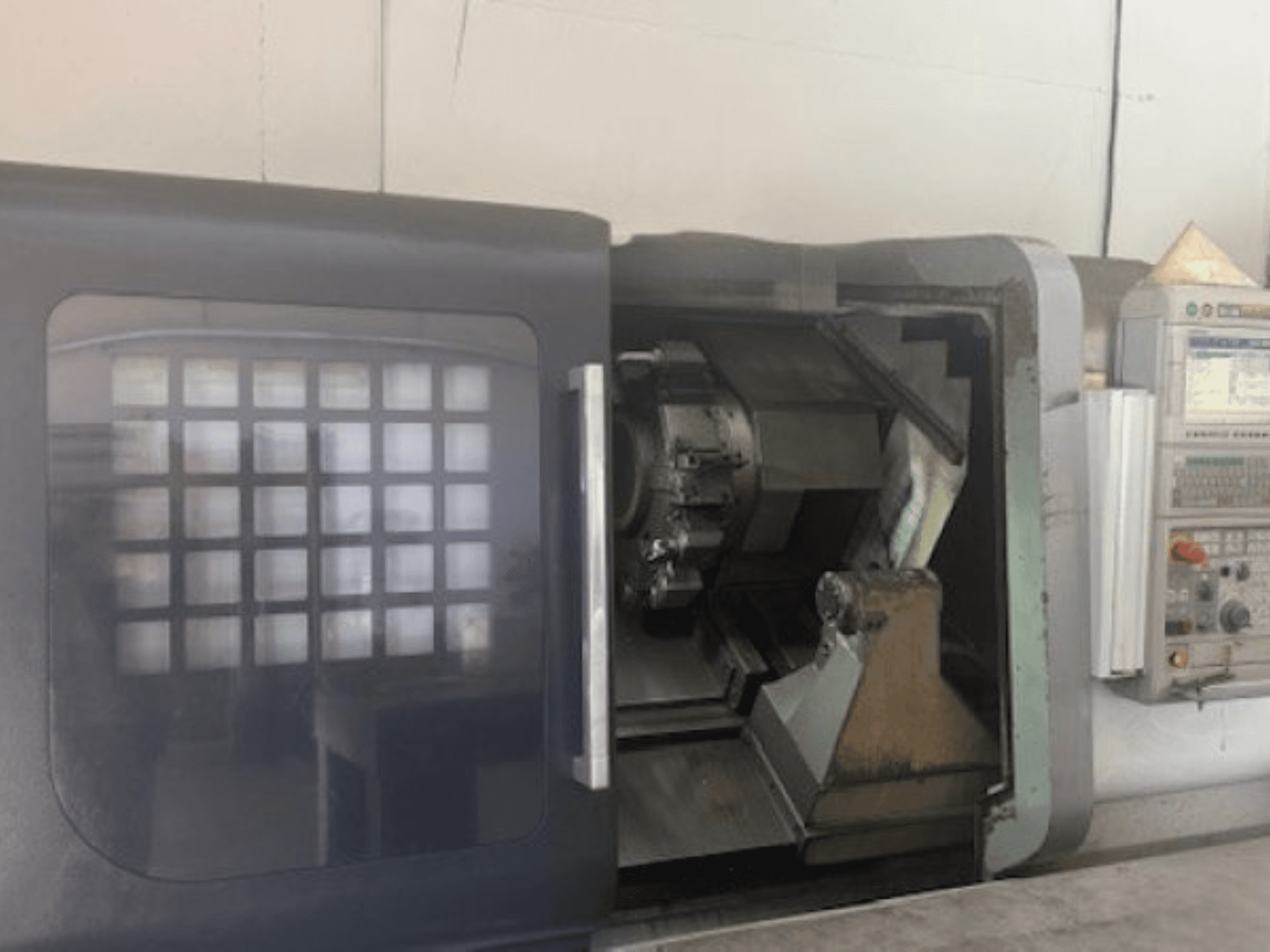 MORI SEIKI NLX 2500M vízszintes esztergagép, elölnézetben a szerszámtartó, a vezérlőpanel és a belső mechanizmus.