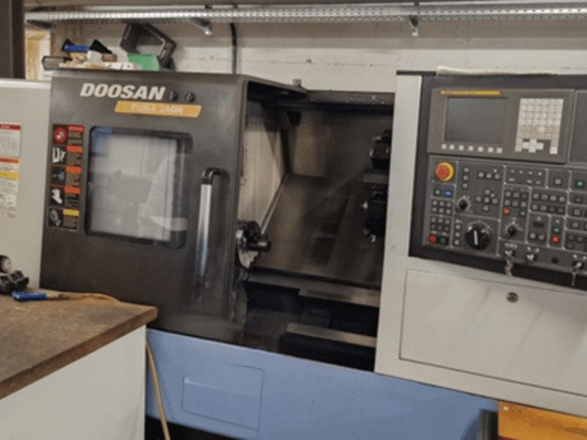 A DOOSAN Puma 240MB vízszintes esztergagép elülső nézete a vezérlőpanel és a működési funkciók bemutatásával.