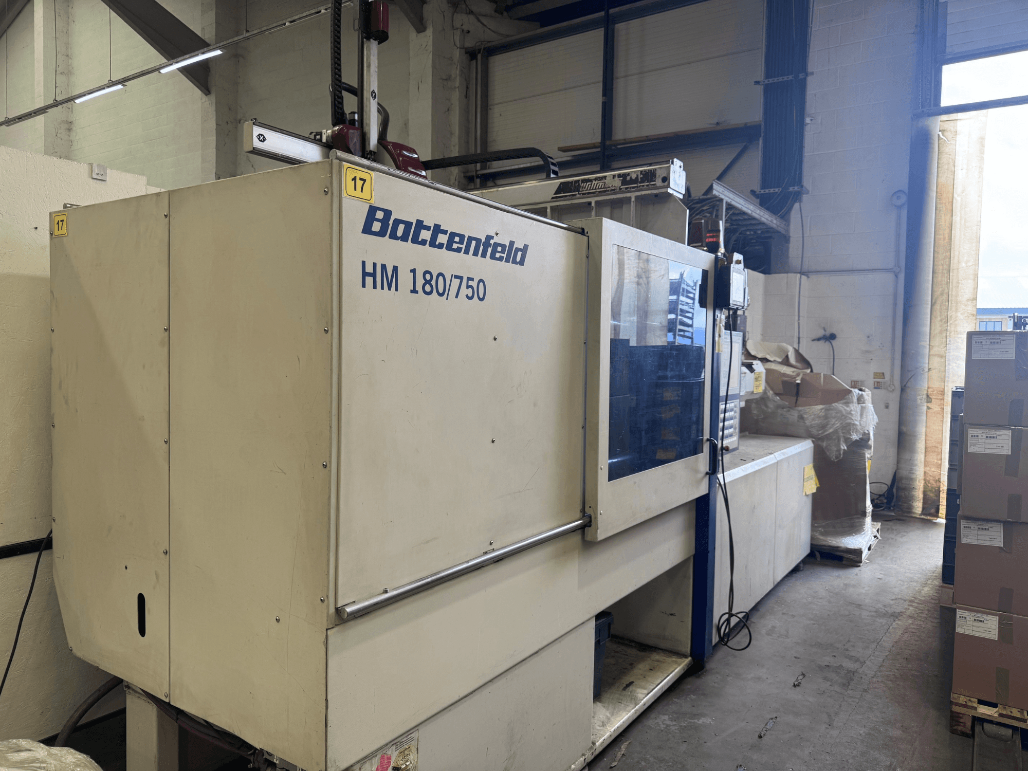 Battenfeld HM150750 hidraulikus fröccsöntőgép szemből, a vezérlőpanel és a környező berendezés bemutatásával.