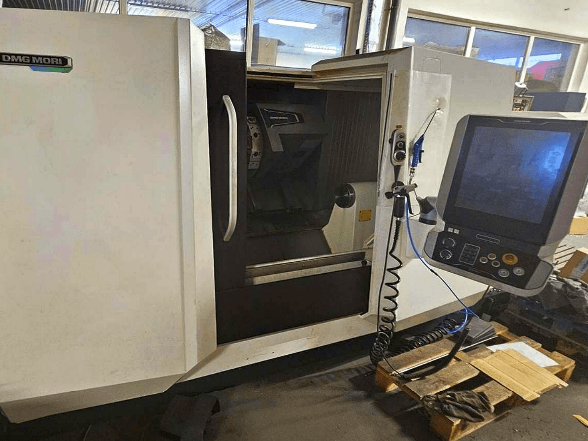 DMG MORI CLX 450 V4 vízszintes esztergagép, elölnézet a kezelőpanellel, a munkaterület és a karosszéria kialakításával.