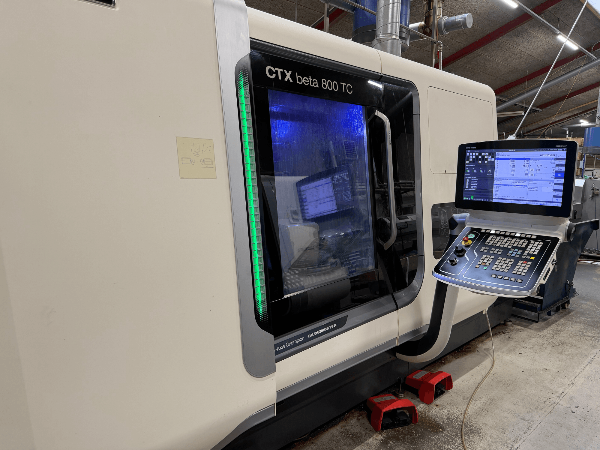 CTX beta 800 TC CNC gép oldalnézetben, digitális vezérlőpanellel és zöld színű biztonsági jelzővel.