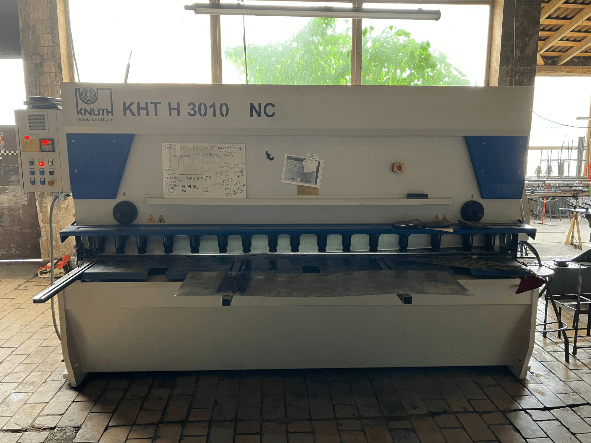 A KNUTH KHT H 3010 NC hidraulikus nyírógép elölnézetben, a vezérlőpanellel és a fémvágó területtel.