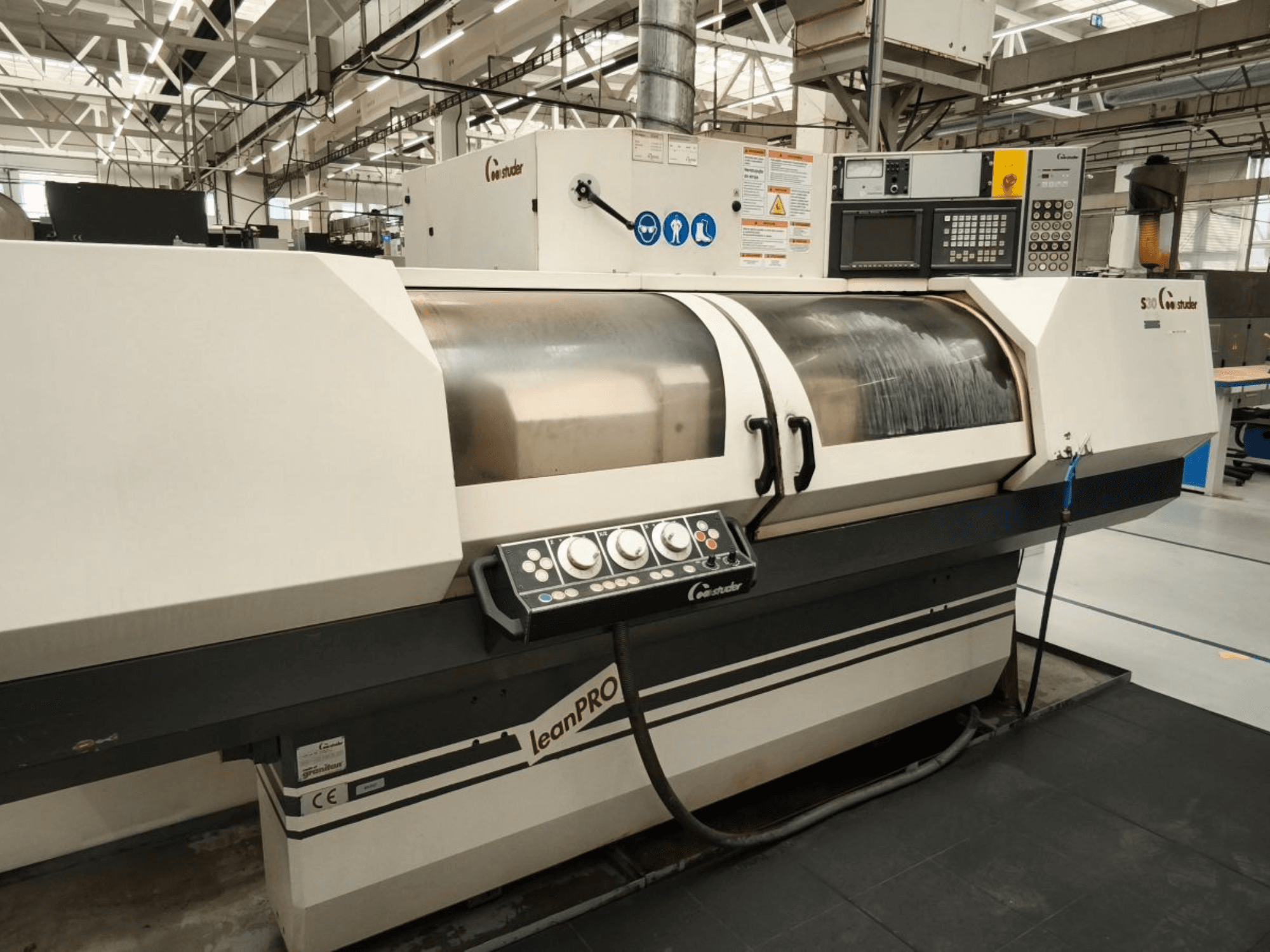 STUDER S30 LEAN PRO hengeres köszörűgép, oldalnézet, a vezérlőpanel és a köszörűkorong fedele ipari környezetben.