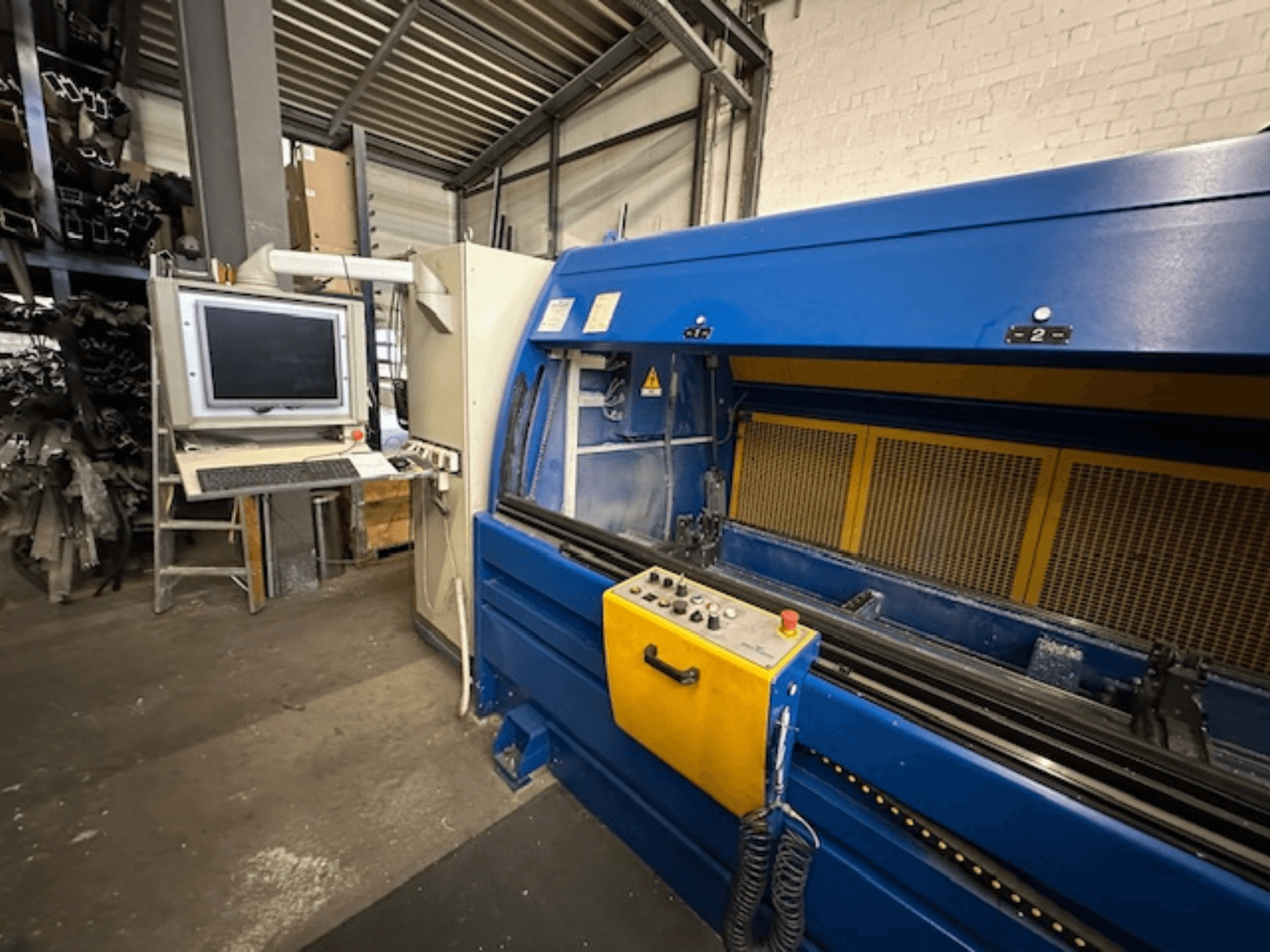 A SCHÜCO Profilbearbeitungscenter 299 650, egy univerzális megmunkálóközpont előlnézetből, vezérléssel és számítógépes munkaállomással.