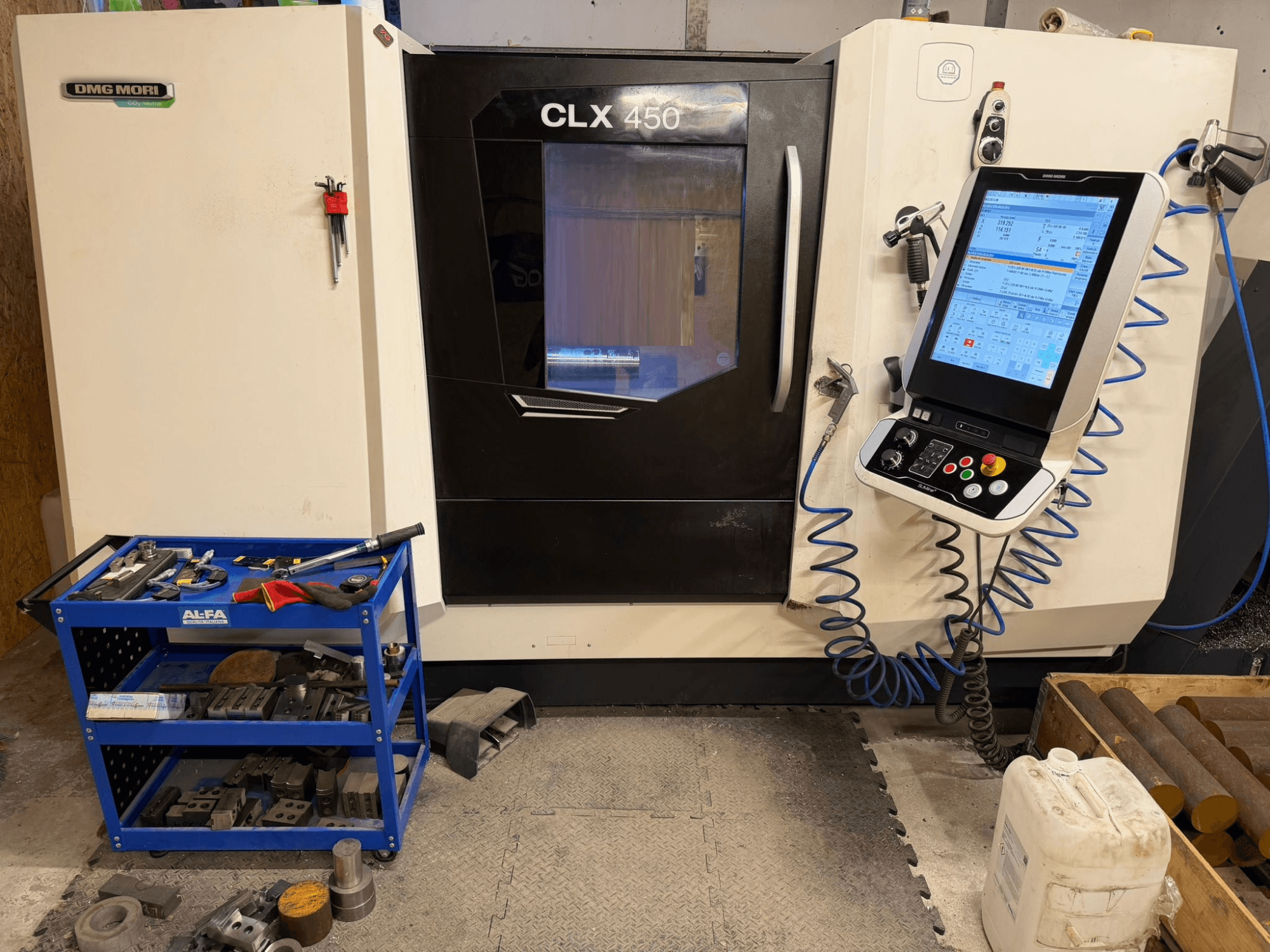 DMG MORI CLX 450 V3 vízszintes esztergagép elölnézetben, vezérlőpanel és a közelben lévő szerszámos kocsi felszereléssel.