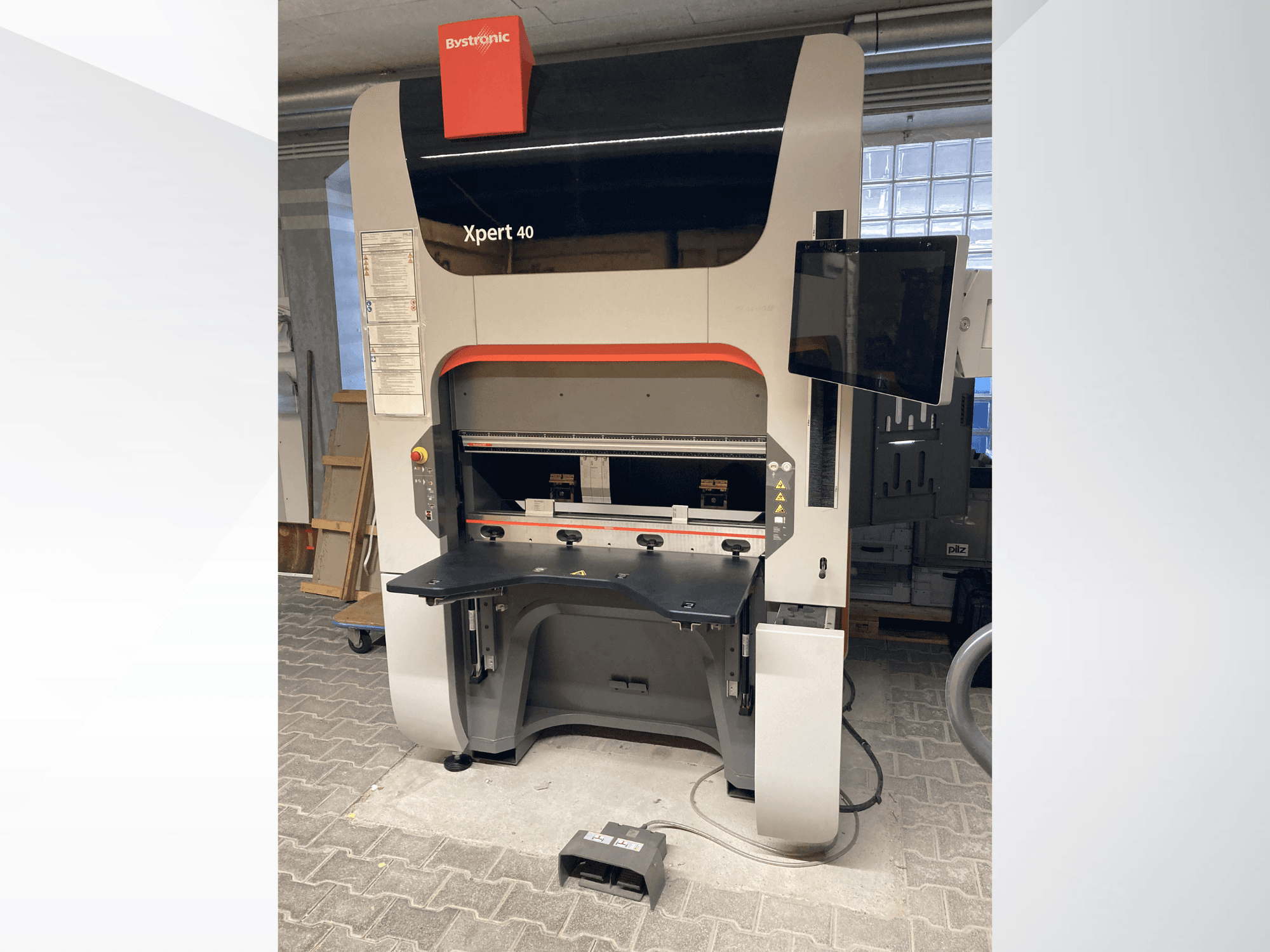 Bystronic Xpert 40/1030 présprés elölnézetben, a vezérlőpanel, a munkafelület és a csatlakoztatott monitor bemutatásával.
