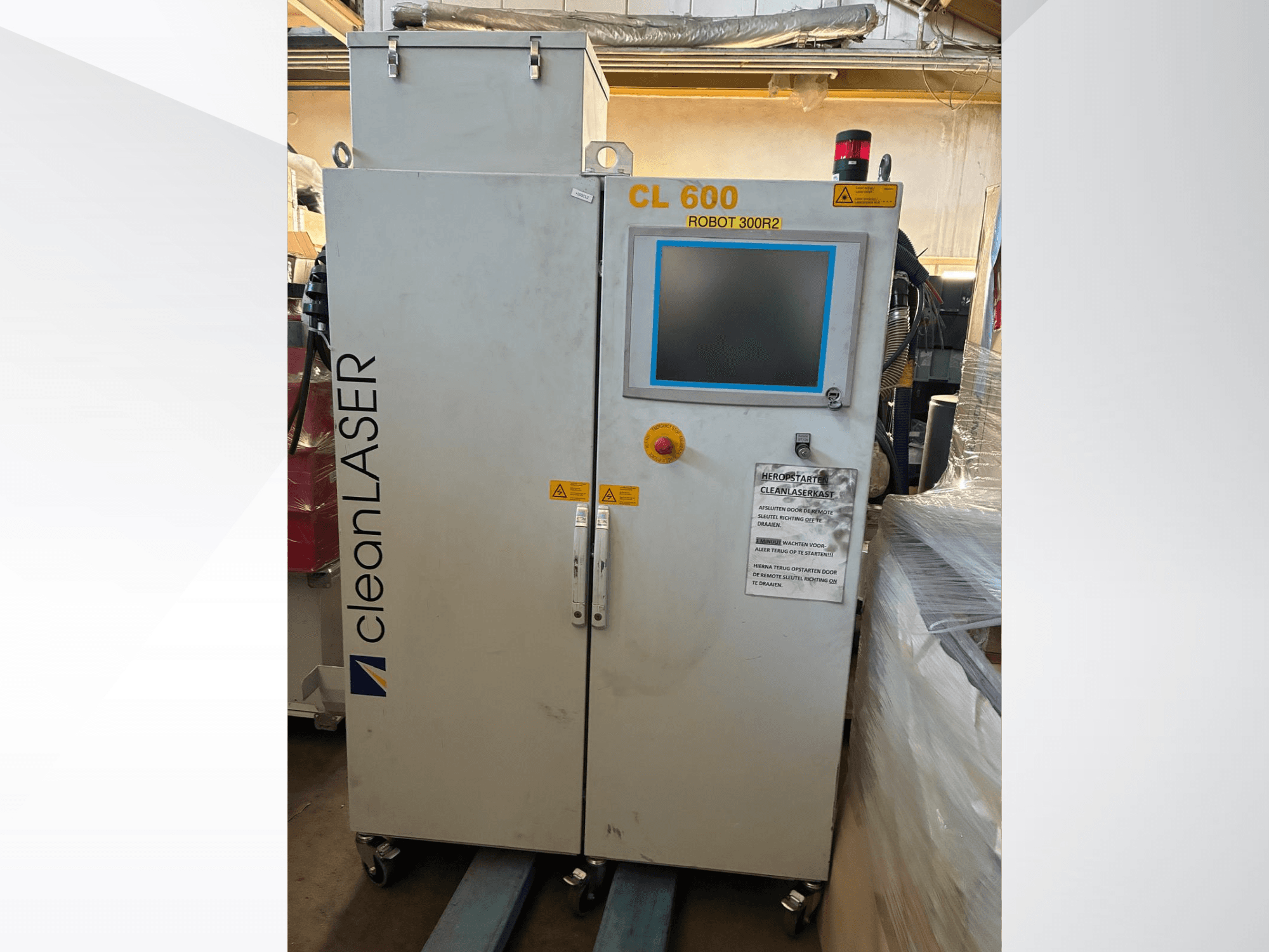 A CLEAN LASER CL 600 automatizálási rendszer elölnézetből, LCD-kijelzővel, figyelmeztető címkékkel és az ajtón elhelyezett vezérlőgombokkal.