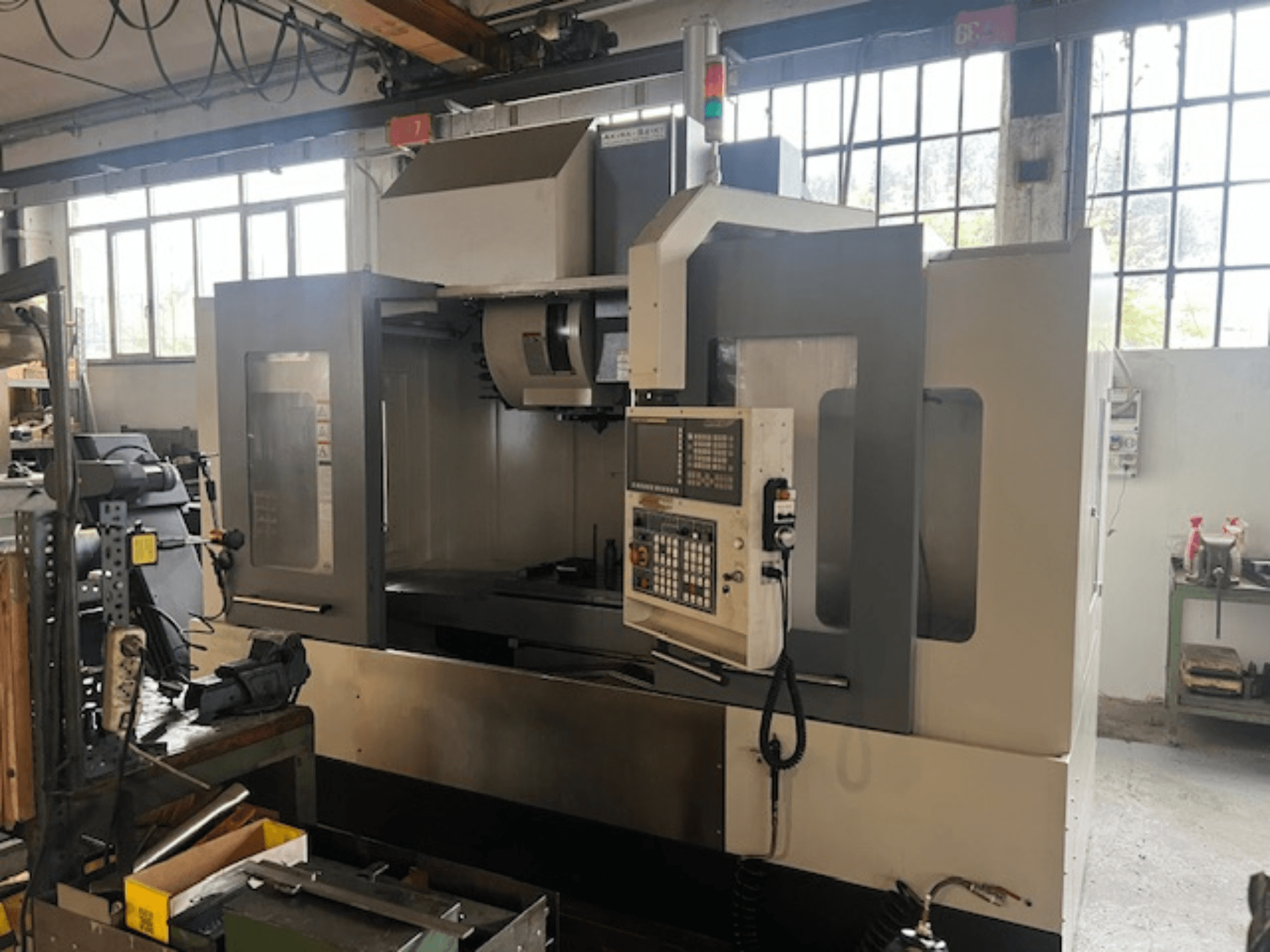 High-tech CNC marógép, elölnézetben, digitális vezérléssel, alapvető biztonsági jelzőkkel és kompakt kialakítással.