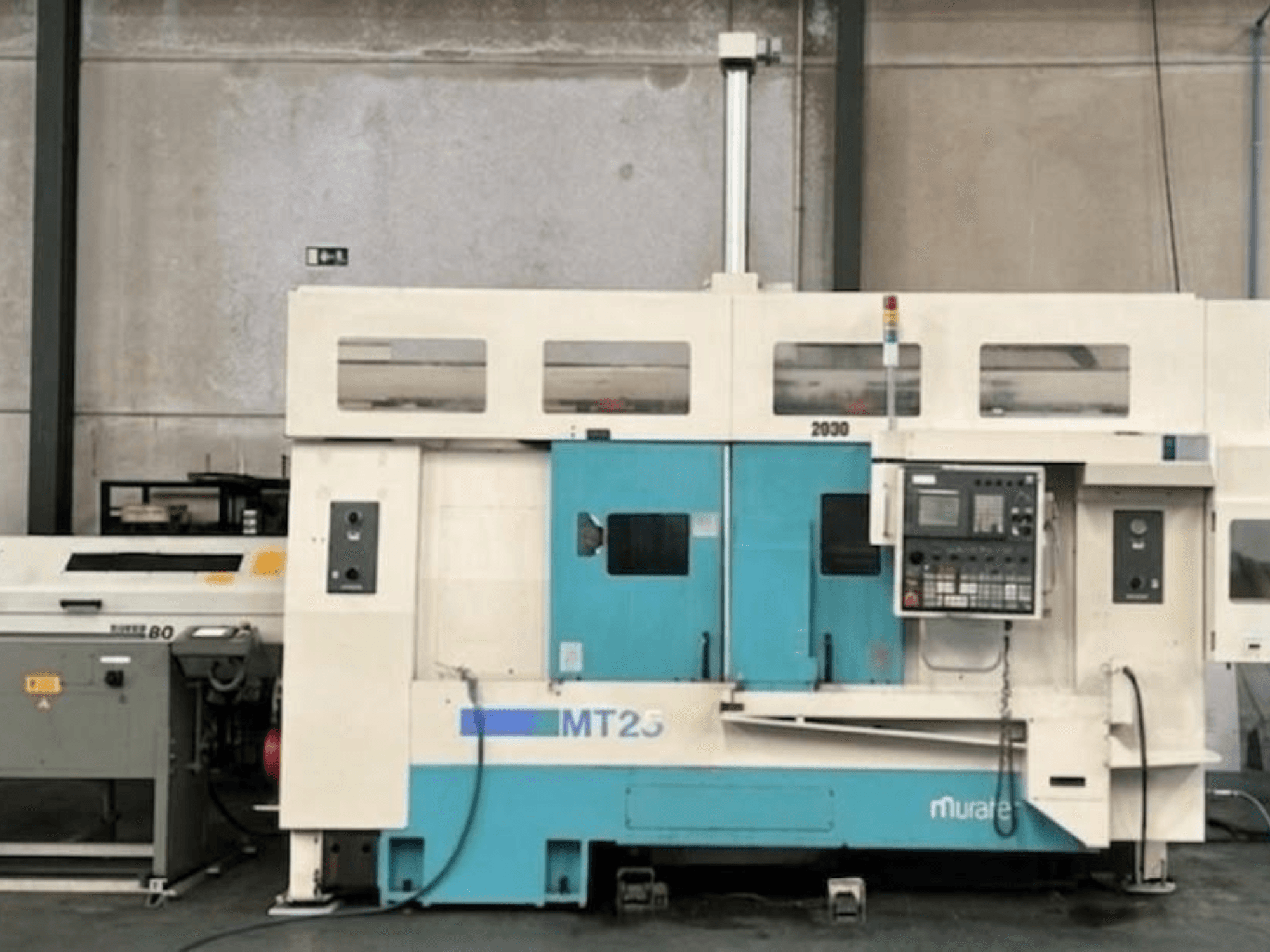 Muratec MT 25 MY esztergályos központ oldalnézetben, vezérlőpanellel és kék-fehér külsővel.