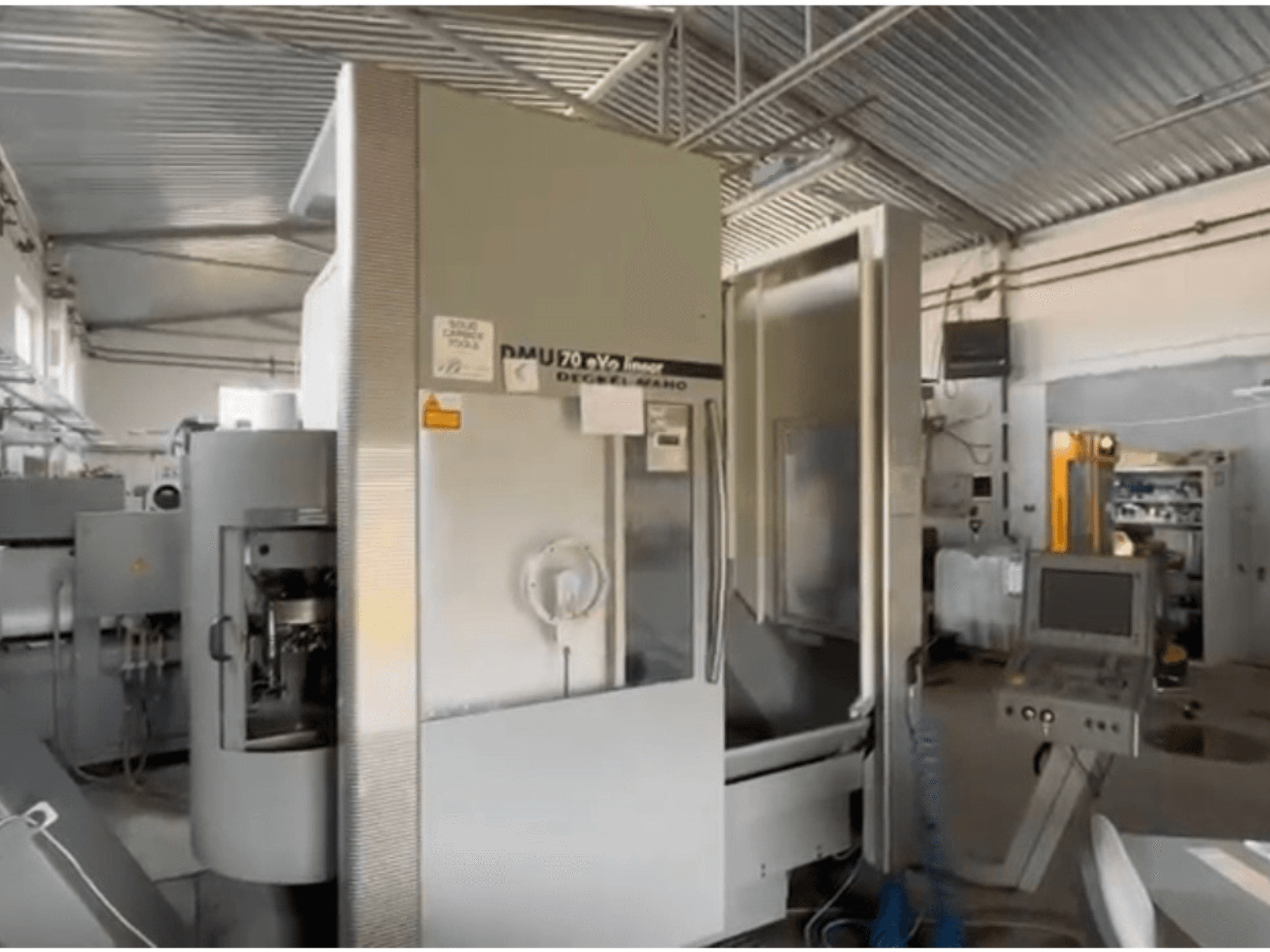 DMU 70 eVo lineáris CNC-gép egy műhelyben, elölnézetben, vezérlőpanel és modern kialakítás.