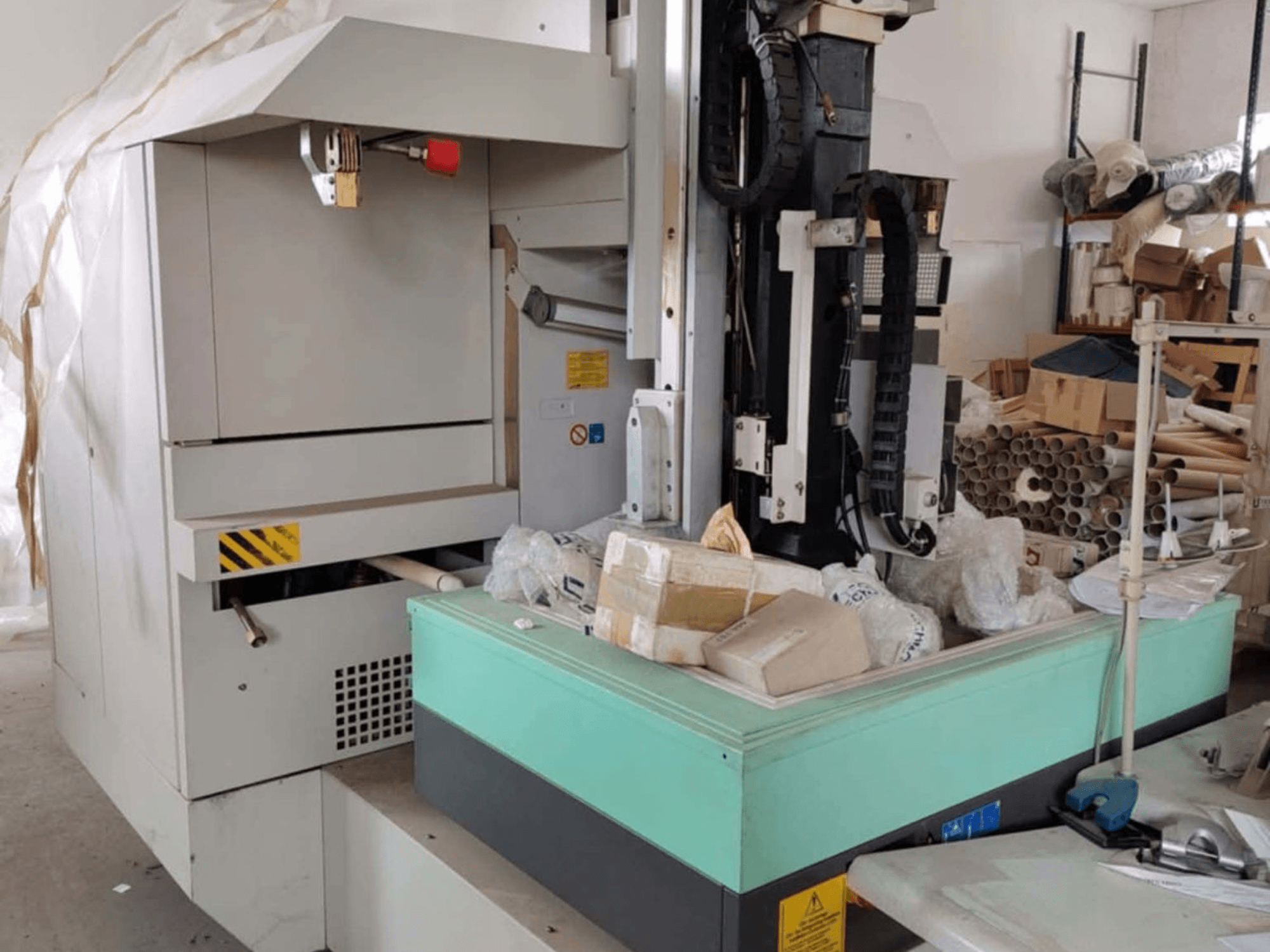 AGIE AGIETRON INTEGRAL 2 süllyesztéses süllyesztéses szikraforgácsoló gép, elölnézet, a vezérlőpanel, a munkaasztal és a környező rendetlenségek.