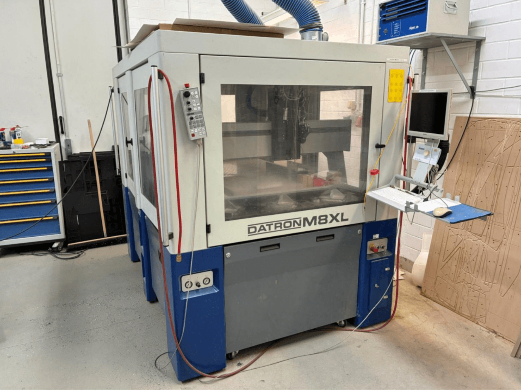 DATRON M8XL CNC-gép egy műhelyben, elölnézetben, mellé szerelt vezérlőpanel és monitor.