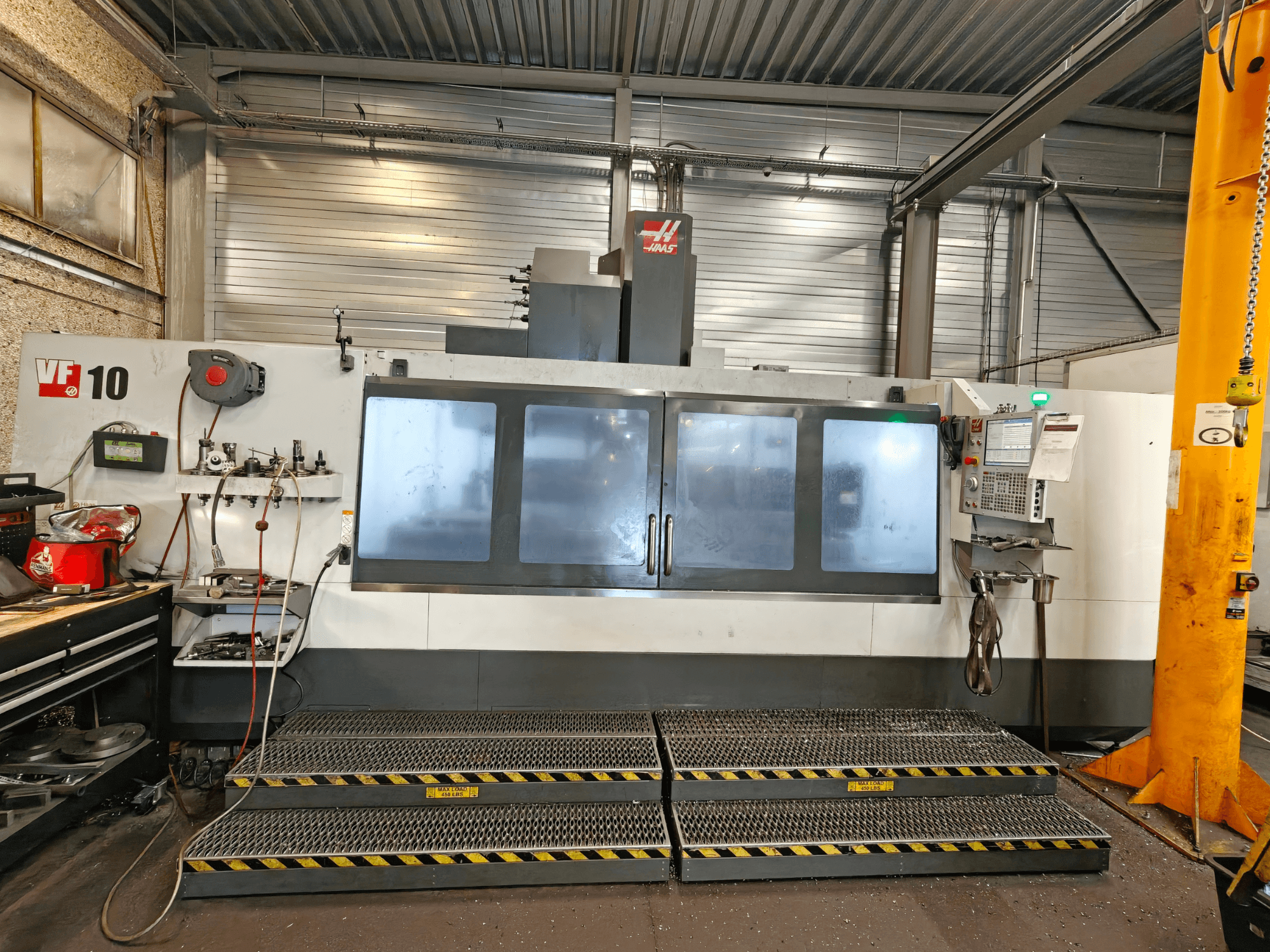 HAAS VF-10/50 függőleges megmunkáló központ, elölnézet, a kezelőpanellel és a nagy ablakokkal.