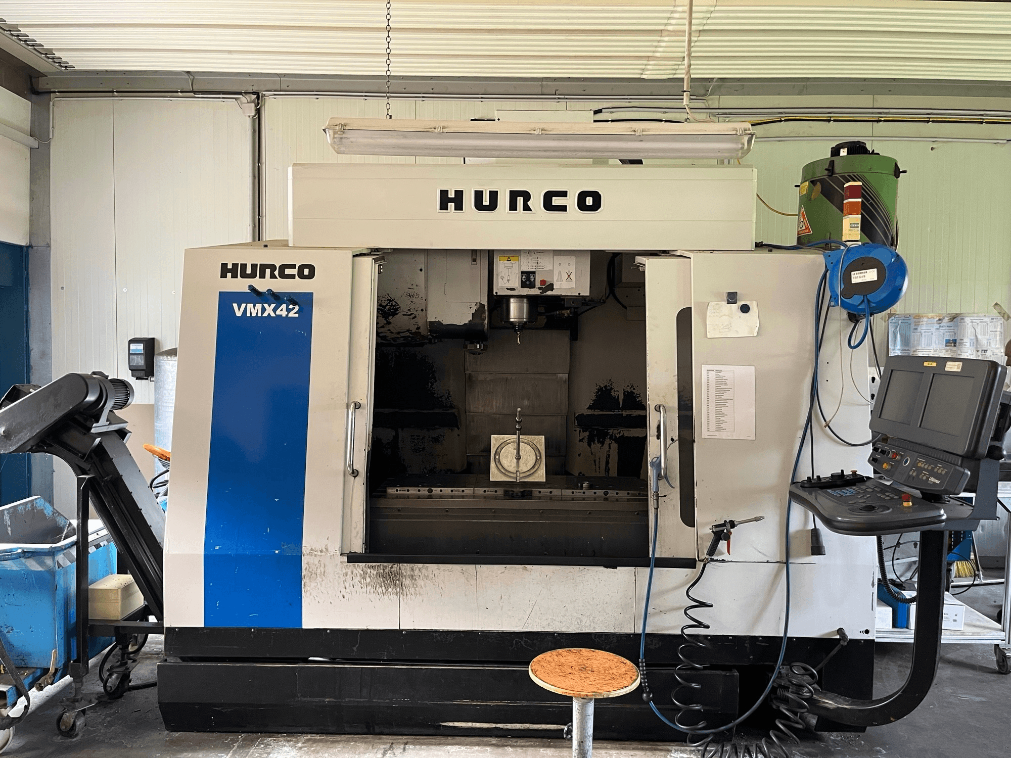 Hurco VMX 42 függőleges megmunkálóközpont oldalnézetben, a vezérlőpanel, az orsó és a munkadarab beállítása.