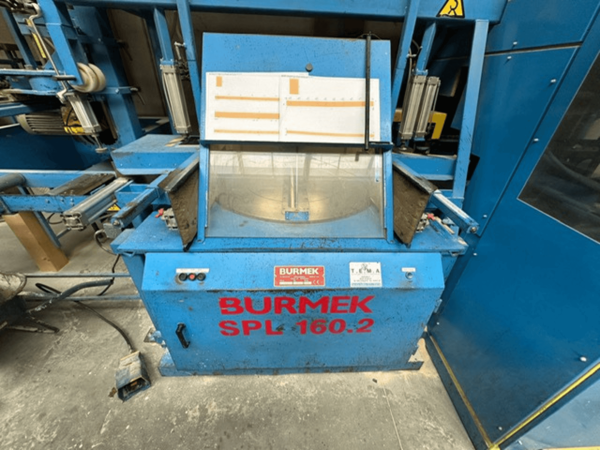 Kék BURMEK SPL 160.2 fagép, elölnézetben, a kezelőgombokkal és a belső teret bemutató üvegpanellel.