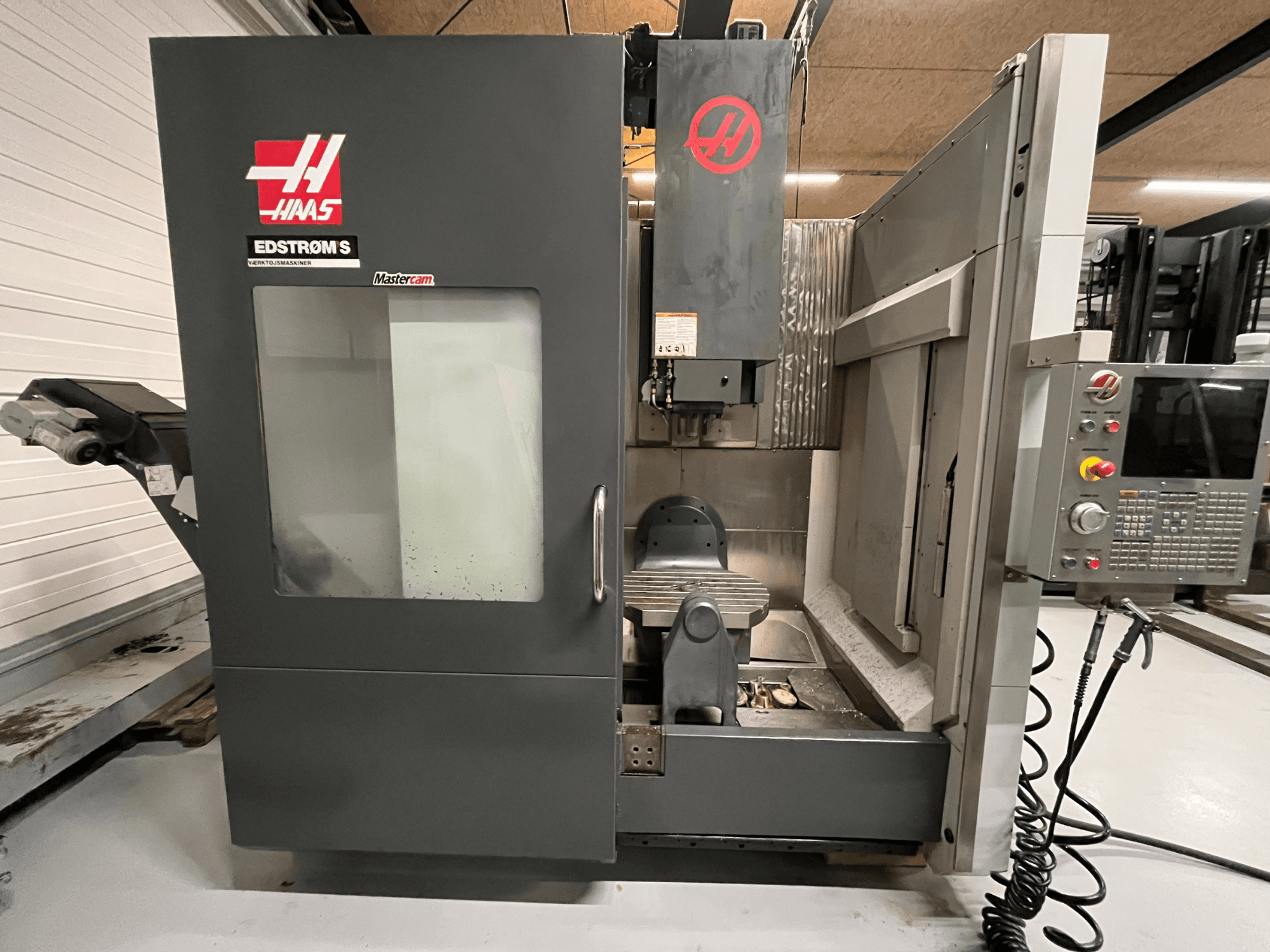 Haas EDSTROM S CNC-gép előlapja, amely a vezérlőpanelt, az orsófejet és a megmunkálóasztalt mutatja.
