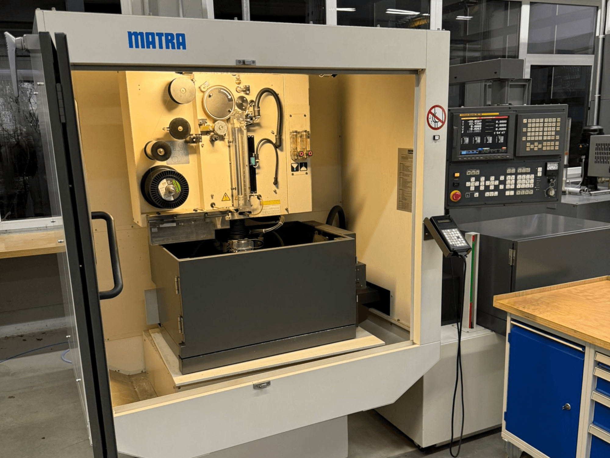 MATRA gép elölről nézve, vezérlőpanel, forgó alkatrészek és egy nagy tárolórekesz.