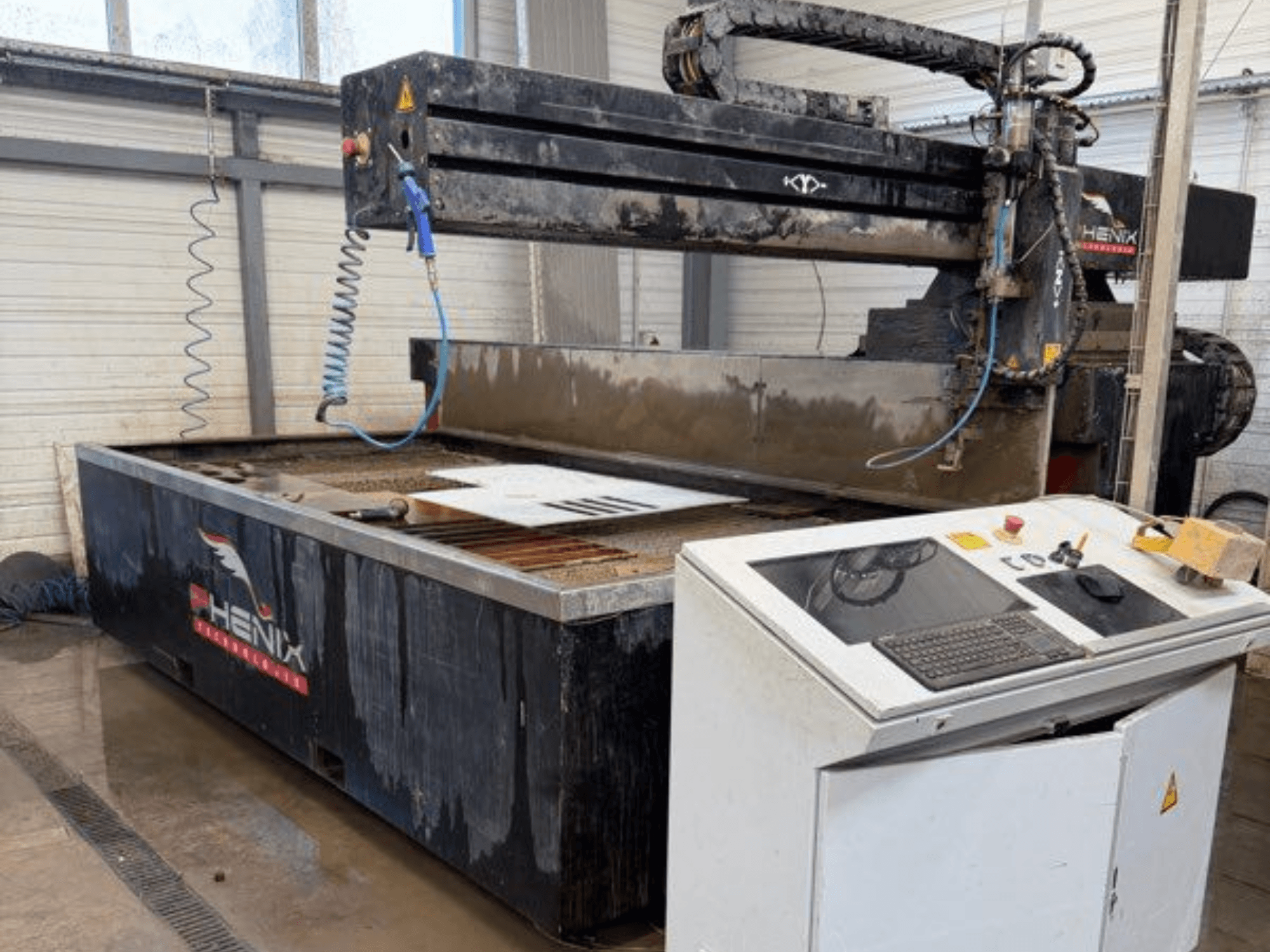 PHENIX MD JET 1530 vízsugaras vágógép, elölnézetben a vezérlőpanel és a vágási terület látható víztartállyal.