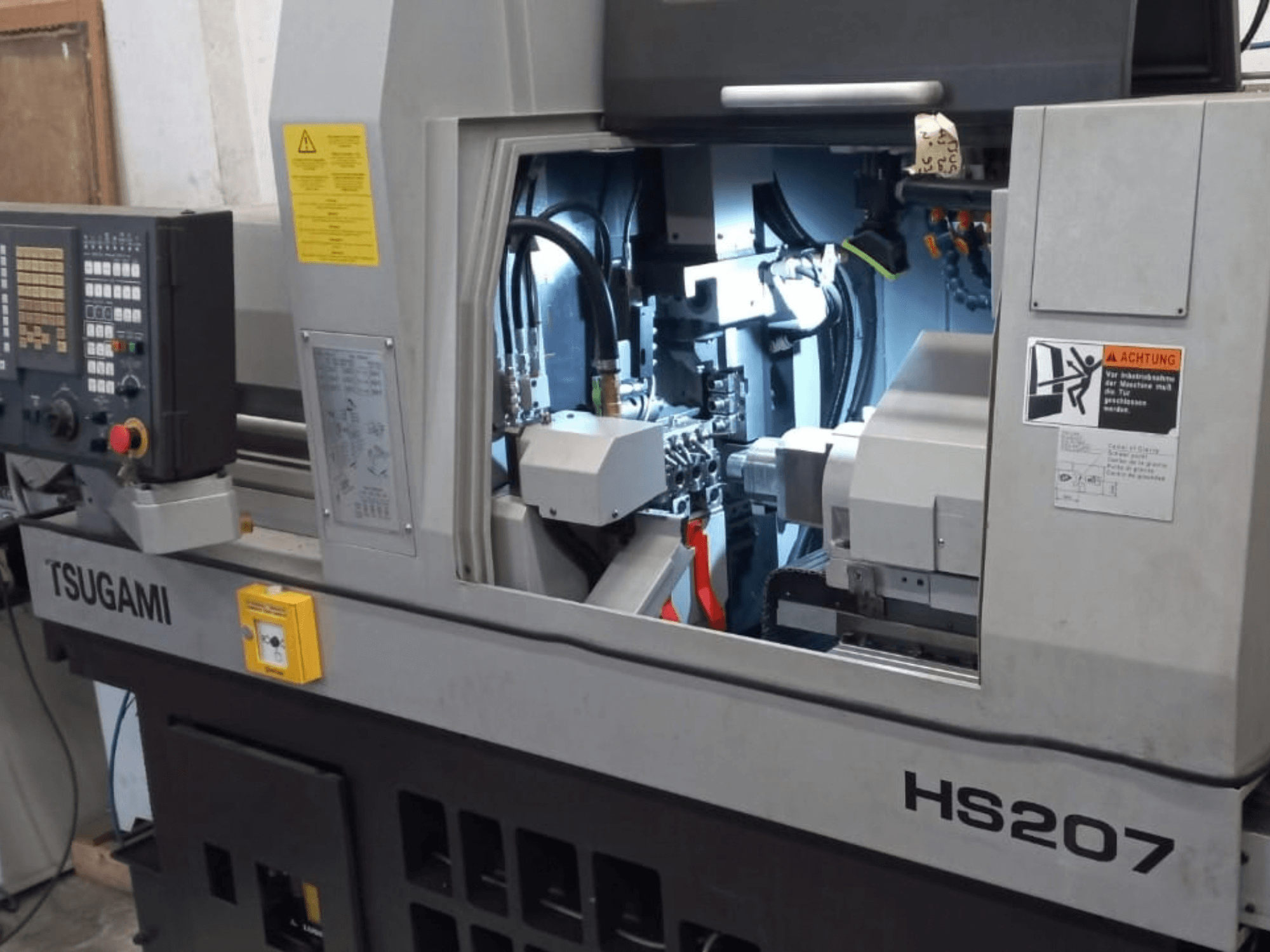 TSUGAMI HS207 svájci típusú eszterga, elölnézet a vezérlőpanellel és a belső alkatrészekkel.